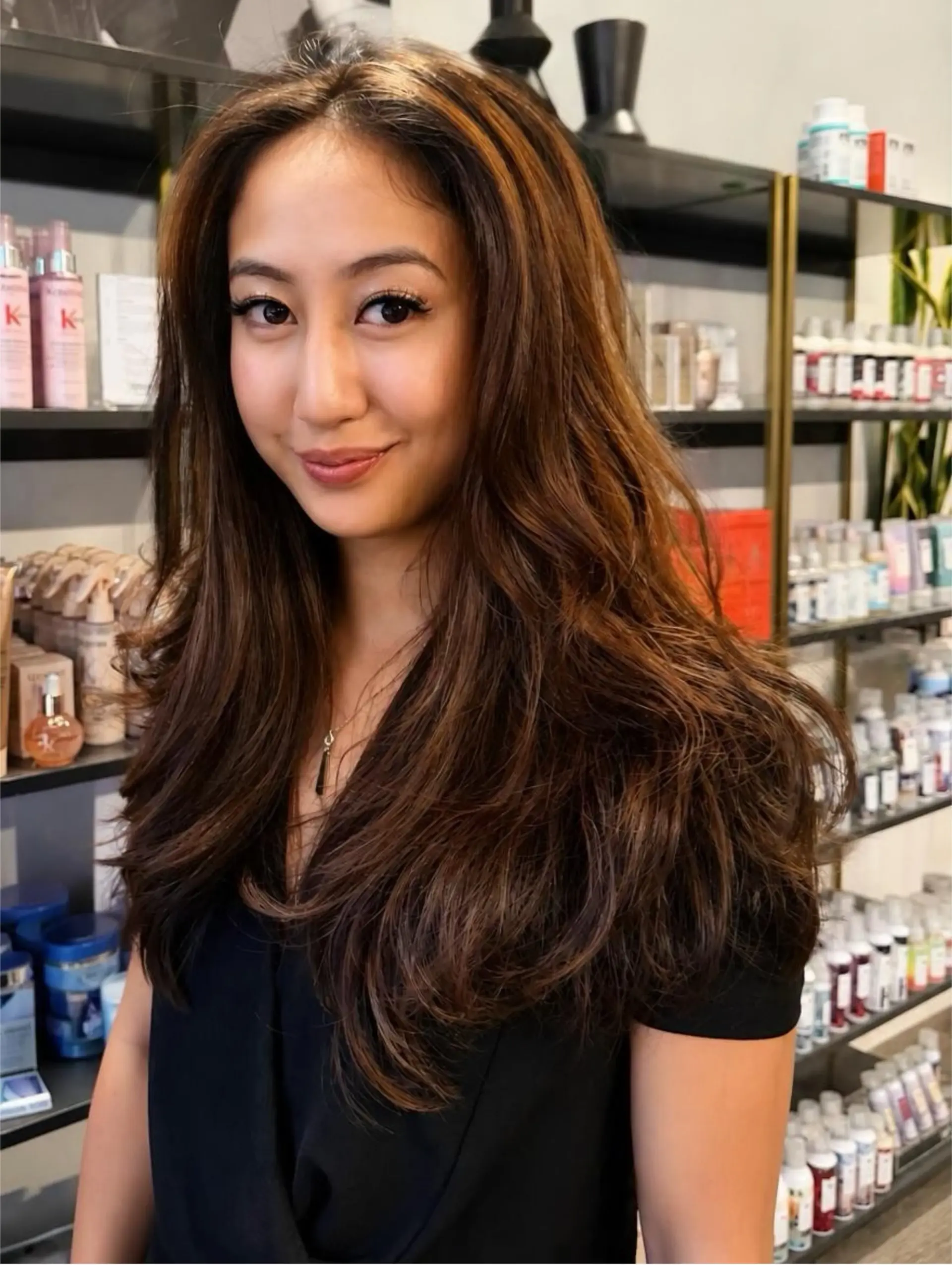 Long cascading brunette hair featuring face-framing layers and styled with soft, voluminous waves. 1