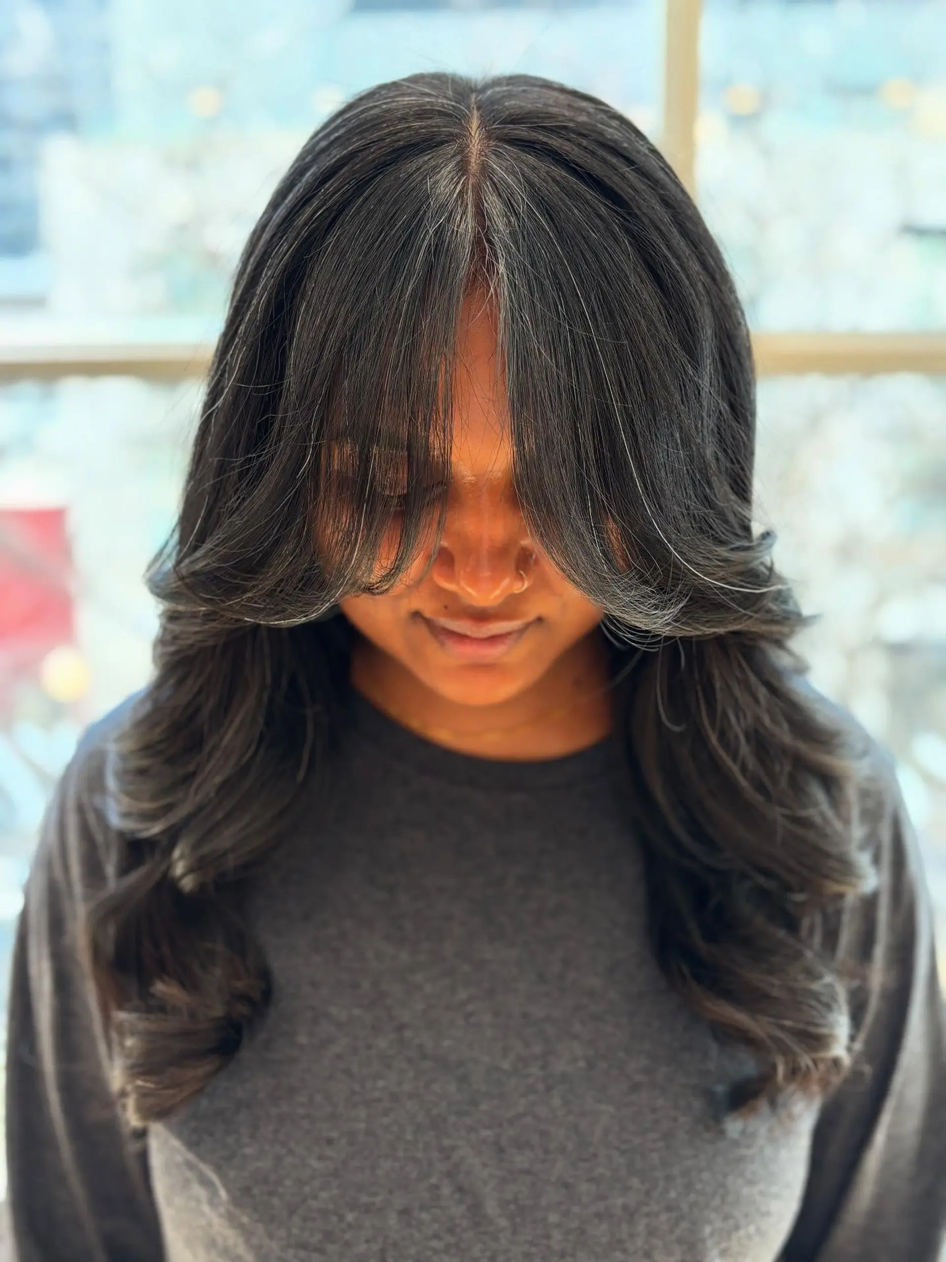 A long, layered hairstyle with face-framing curtain bangs. 1