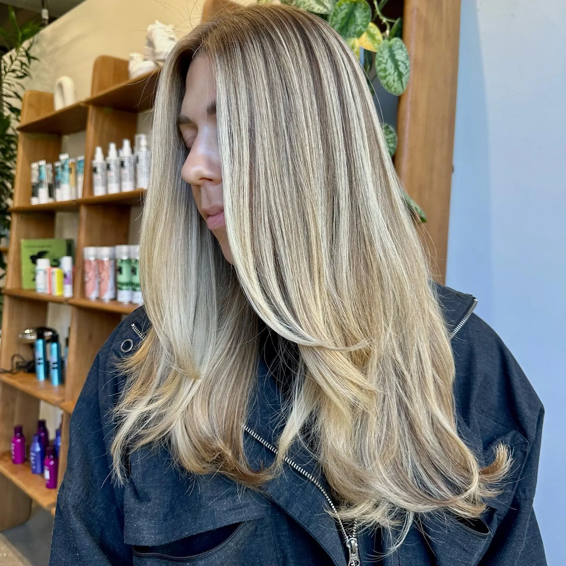 Long layered haircut with face-framing layers, styled to showcase a dimensional ash blonde color. 1
