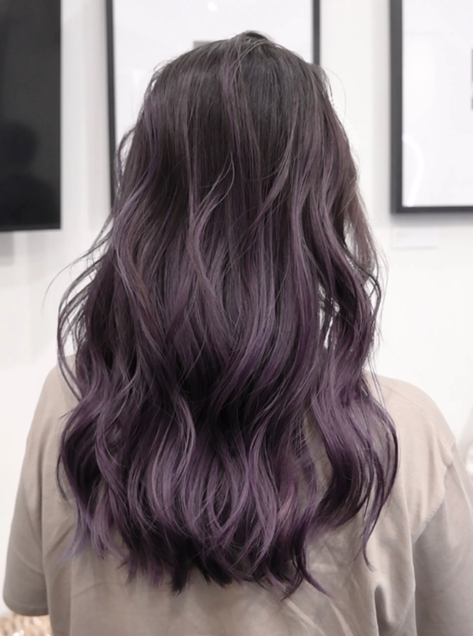 Long, wavy hair with an ombre balayage transitioning from black roots to purple ends, and layered for volume and movement. 1