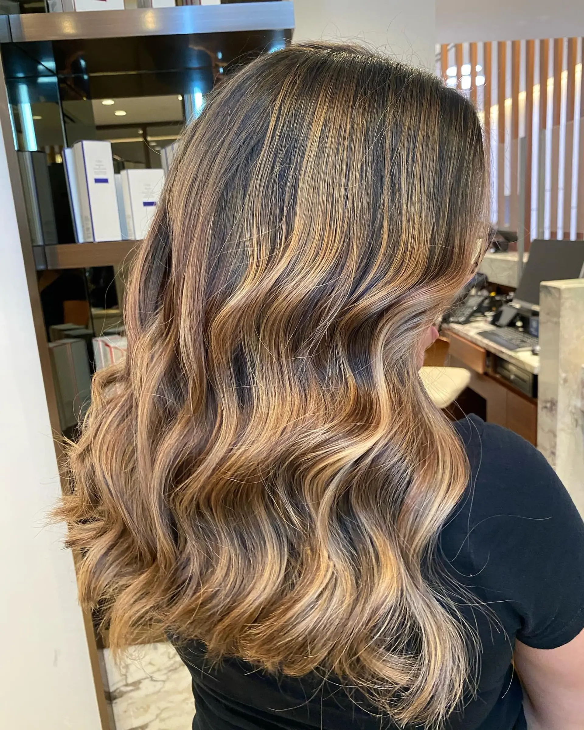 Long, layered hair with soft waves and a blended balayage color melt. 2