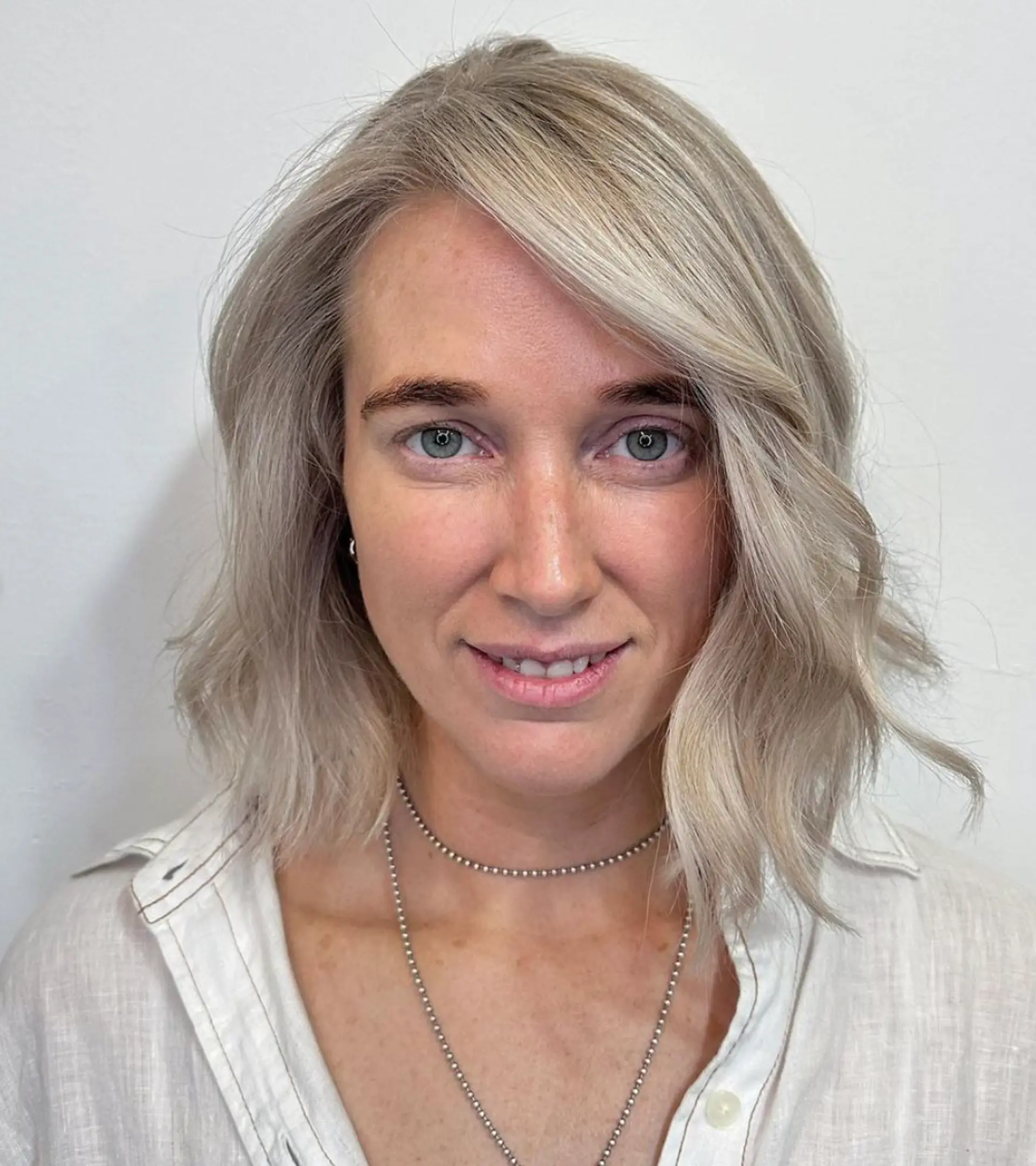 A medium-length, wavy hairstyle with a side part and textured ends, colored in icy silver and platinum shades.

Color by @simabeautynyc
Cut by @juliamannino_hair
 2