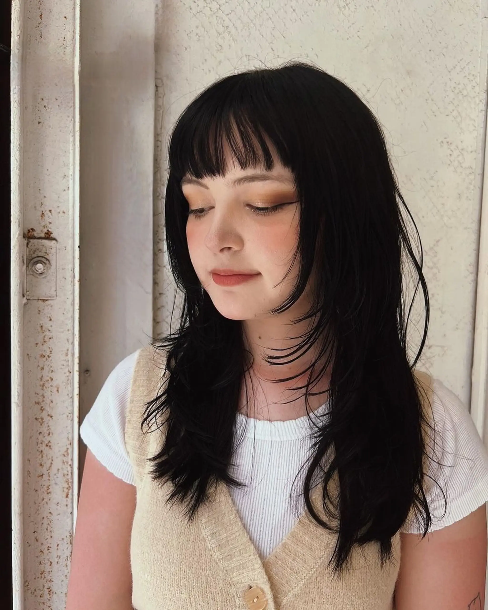 Long straight hair with soft cascade layers and a choppy fringe, providing a natural, breezy appearance.