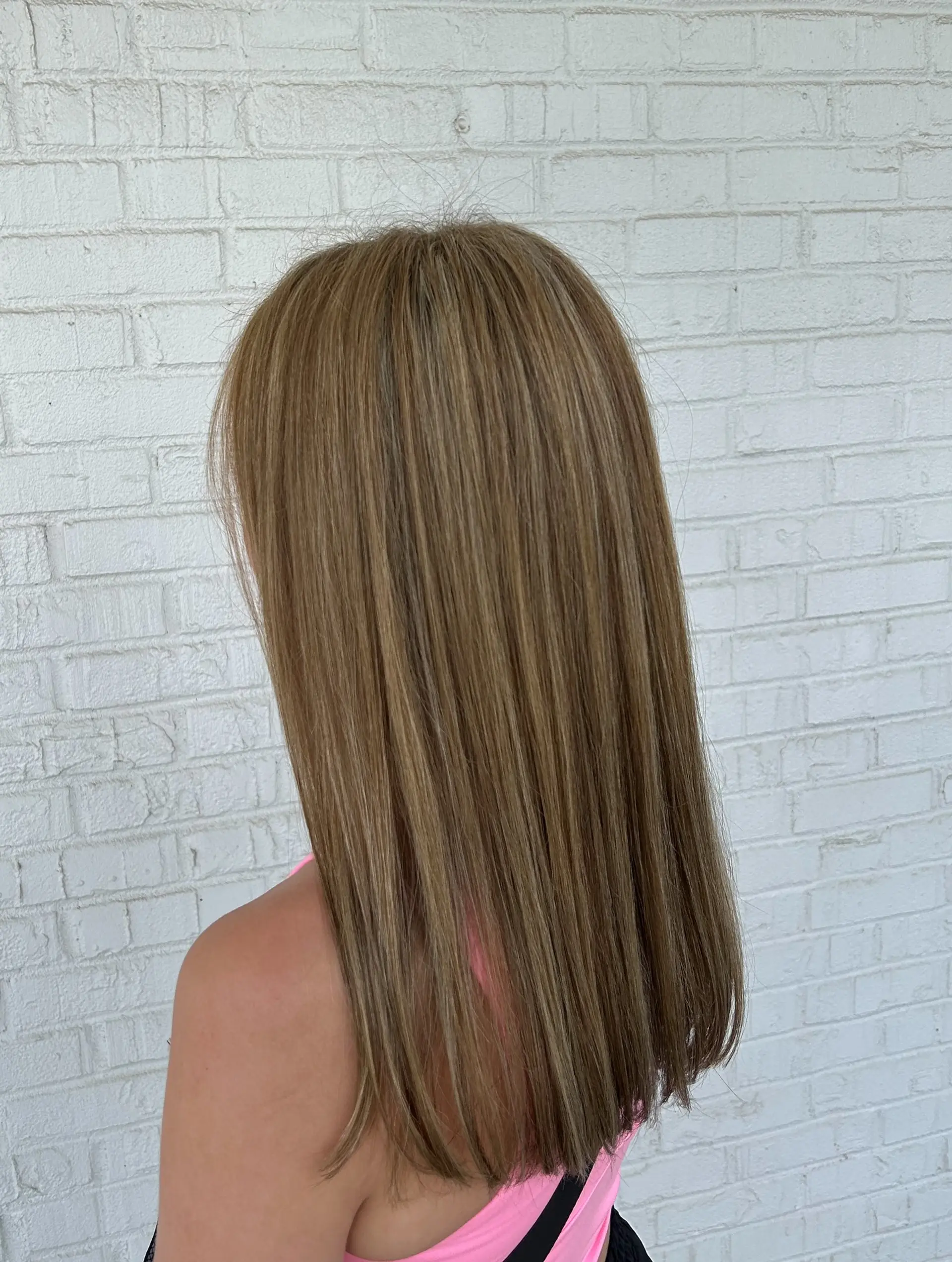 Straight, mid-to-long hair featuring blended honey blonde highlights over a light brown base for a multi-tonal bronde look. 1