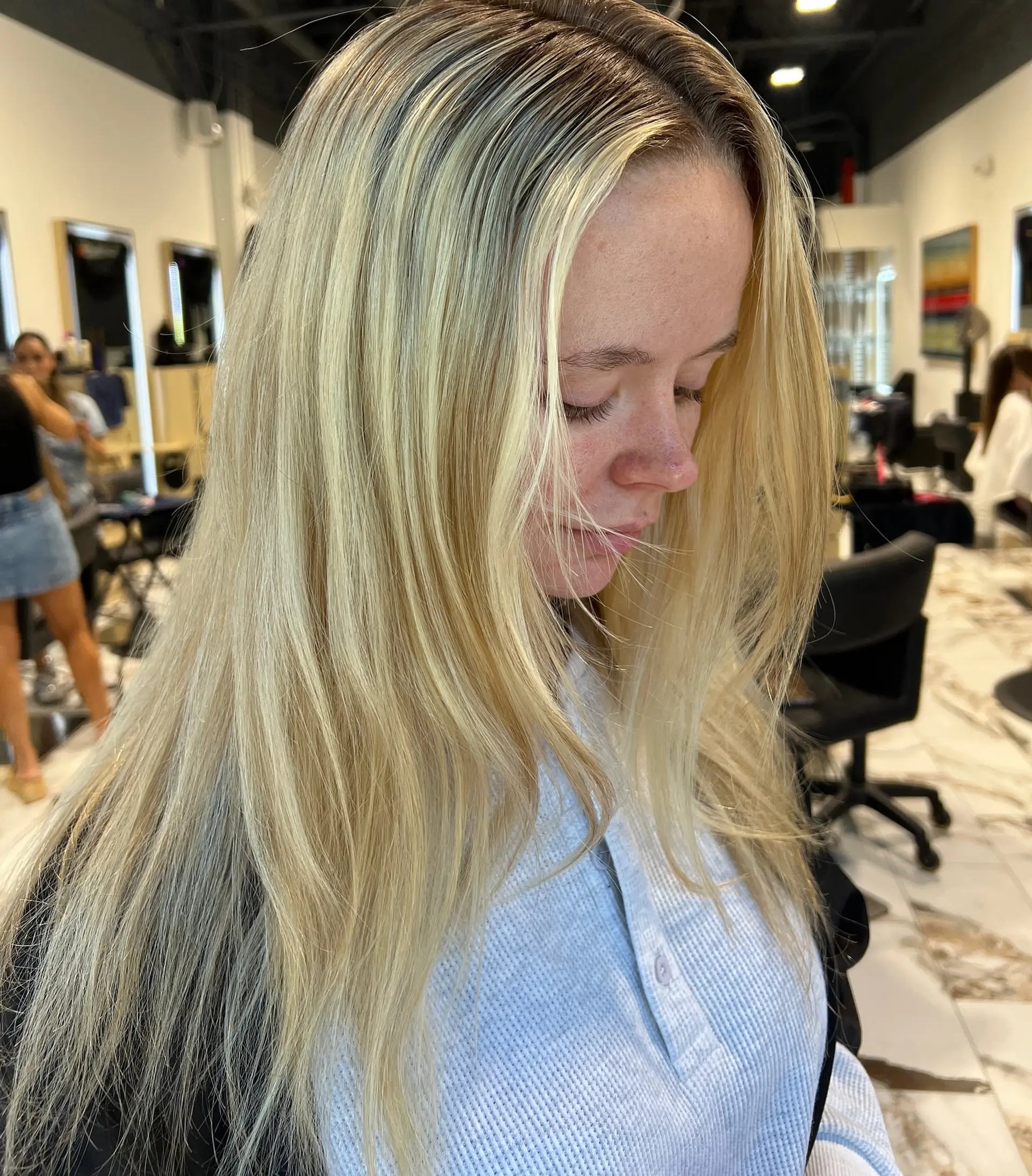 Long straight dimensional blonde hair styled with soft face-framing layers and a root shadow. 1