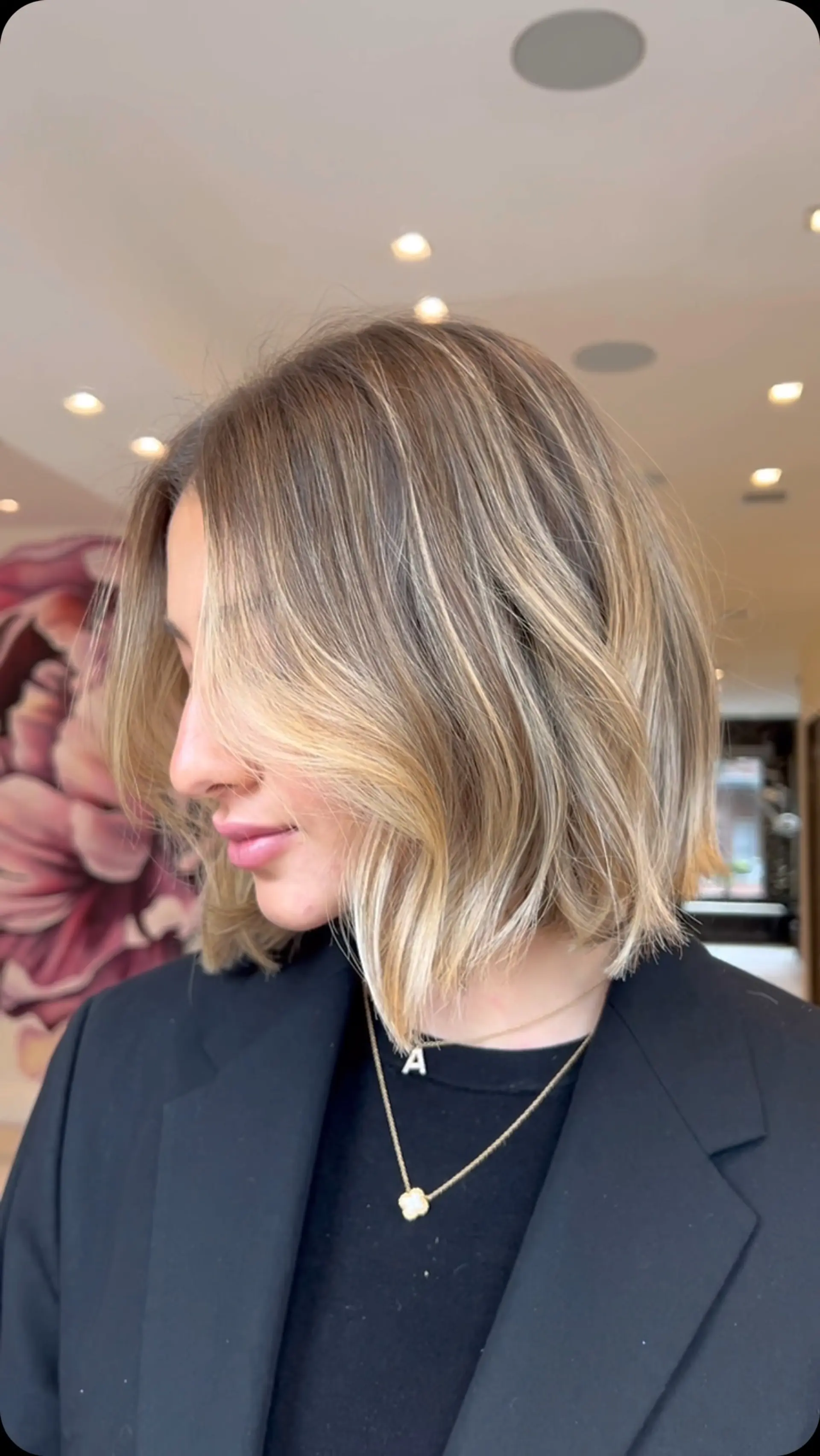 A textured chin-to-collarbone bob featuring soft, dimensional blonde balayage highlights with natural root blending, styled in subtle loose waves. 1