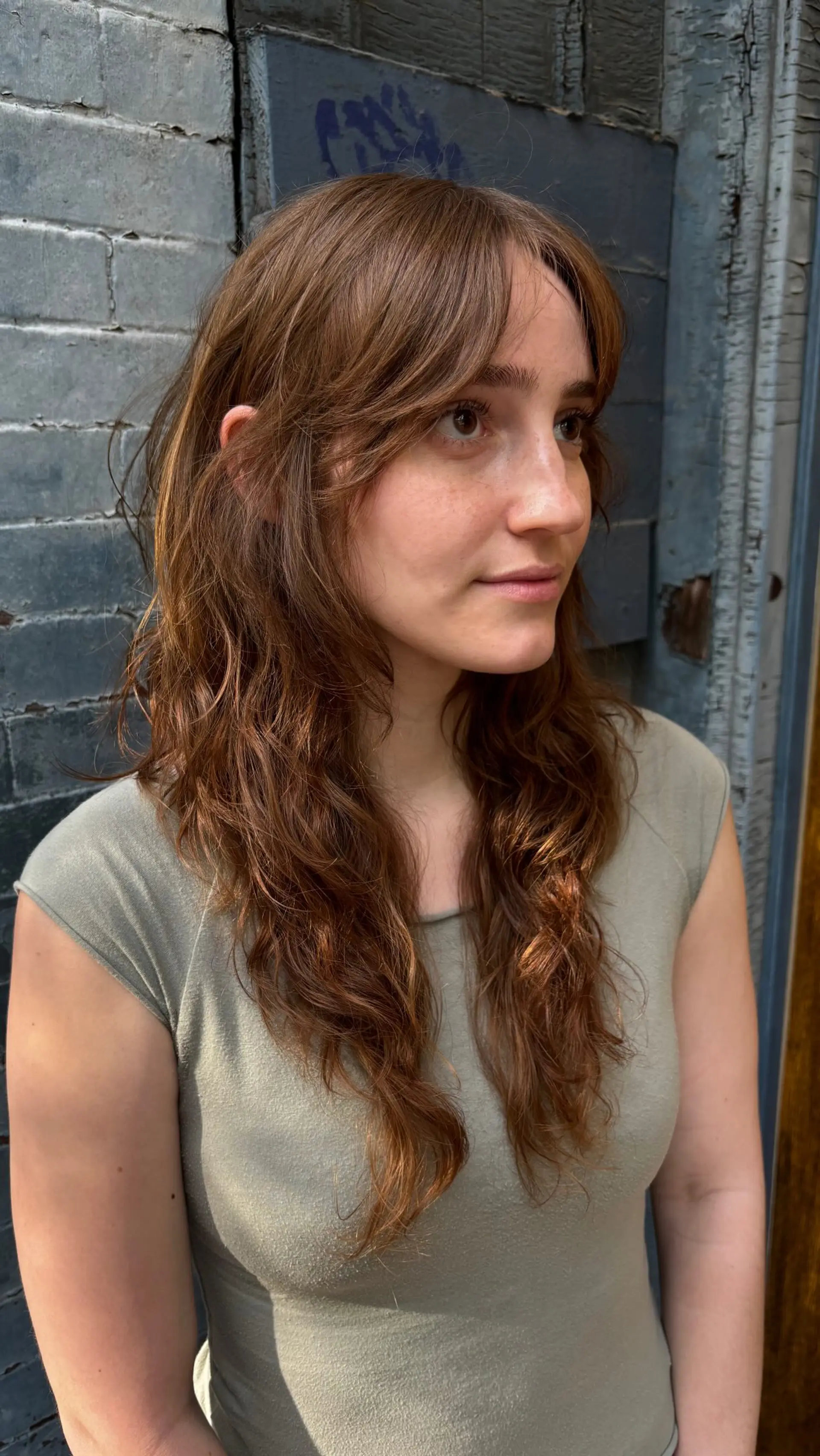 A long, textured shag haircut featuring soft, piecey curtain bangs and natural wavy layers. 1
