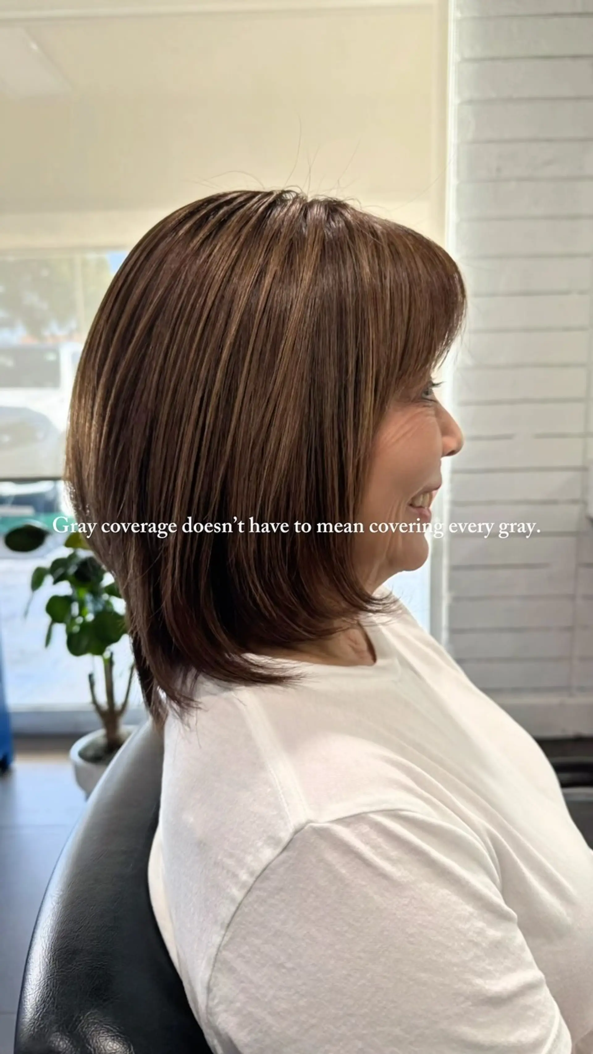 A medium-length layered bob featuring warm brown hair color with natural gray blending and face-framing bangs. 1