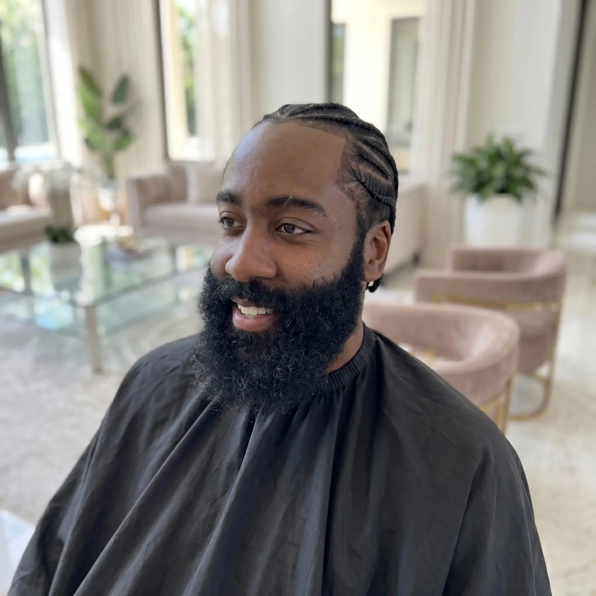 Clean cornrows paired with a sharp edge-up hairline and a full, groomed beard. 1
