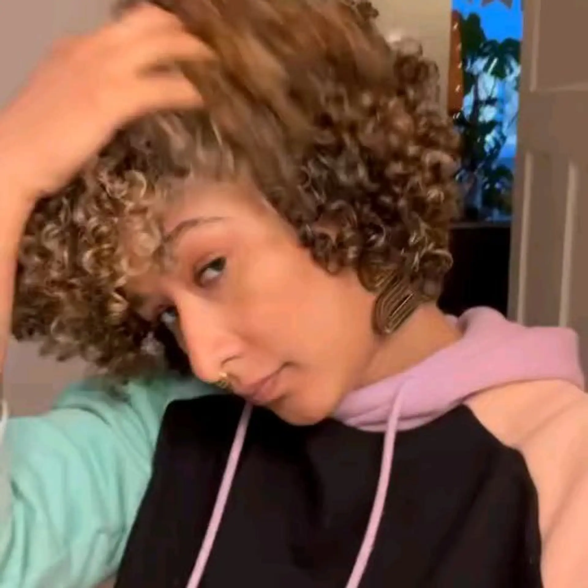 A short, voluminous curly bob featuring defined ringlets, textured fringe, and sun-kissed caramel balayage highlights. 1