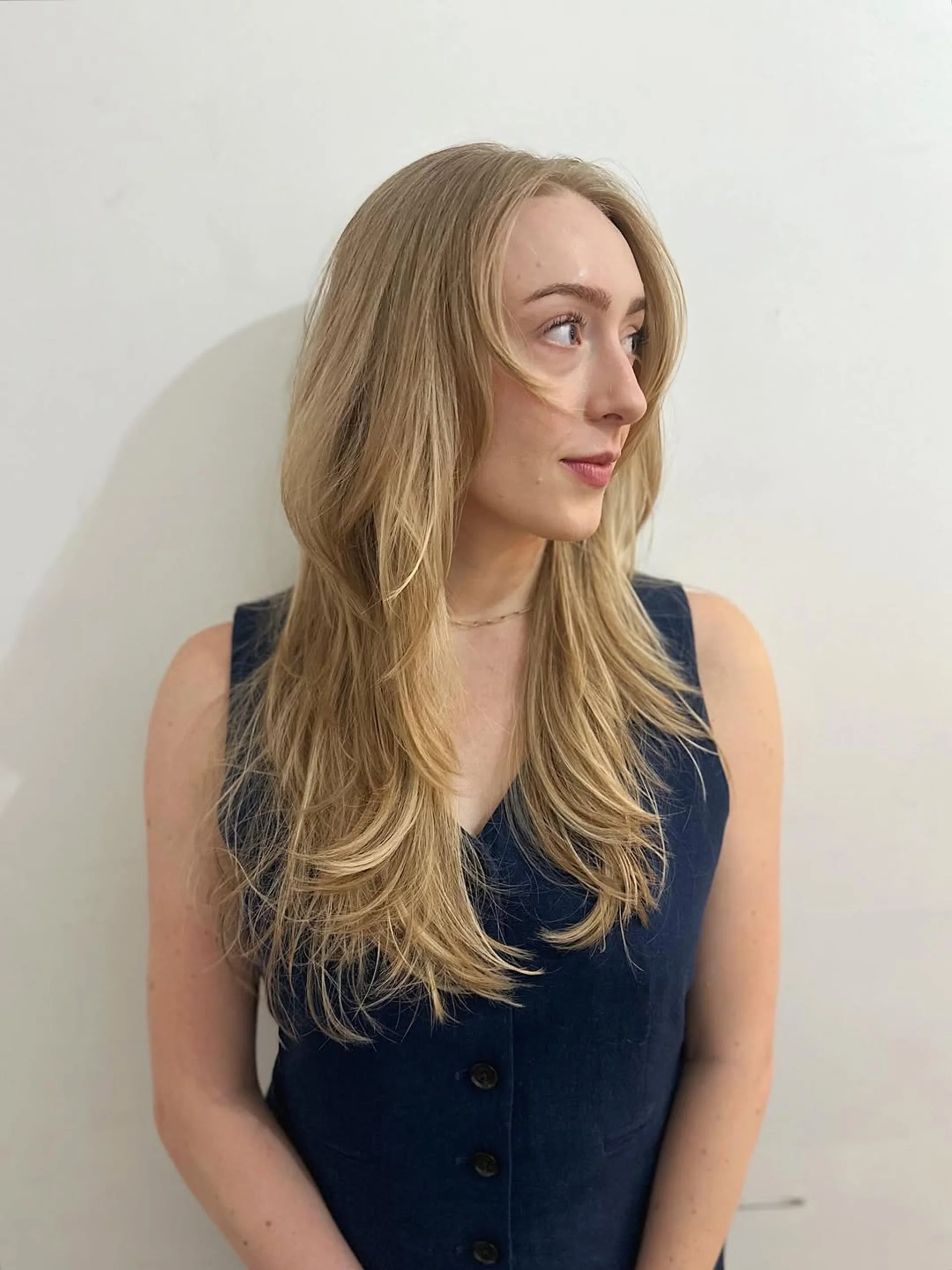 Long blonde hair styled with beach waves, long layers, and curtain bangs - Preview 3