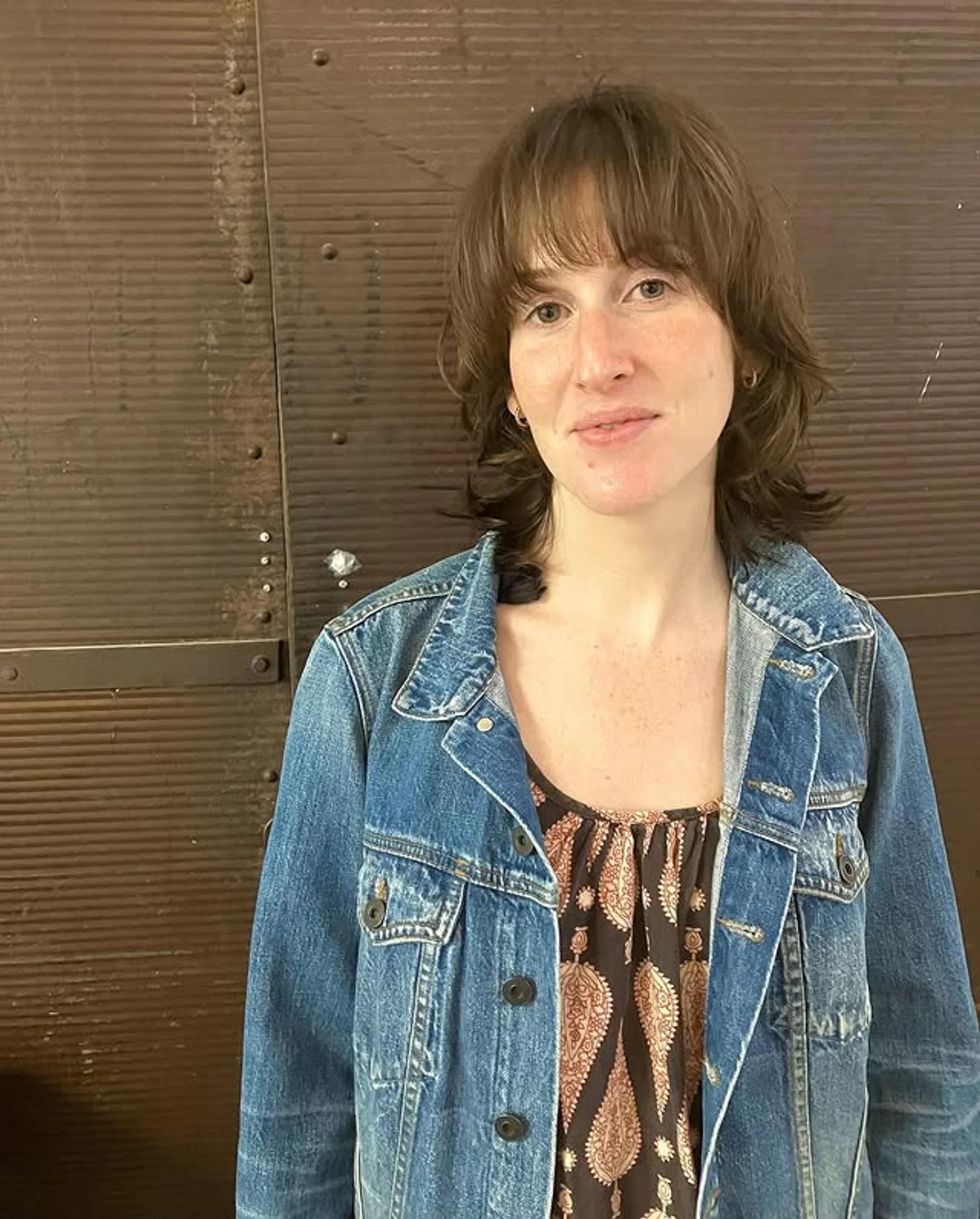 A model with a 70s-inspired layered shag haircut and curtain bangs, showcasing the 2025 retro-futurism hair trend. - Preview 3