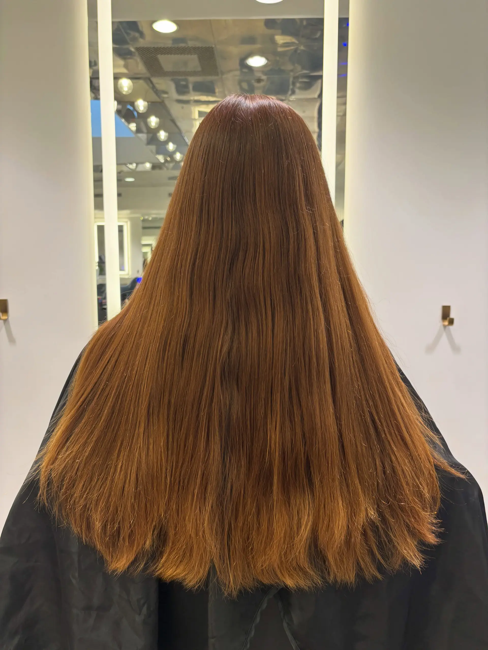 Long, straight auburn hair with subtle layering at the ends and a smooth, glossy finish. 1