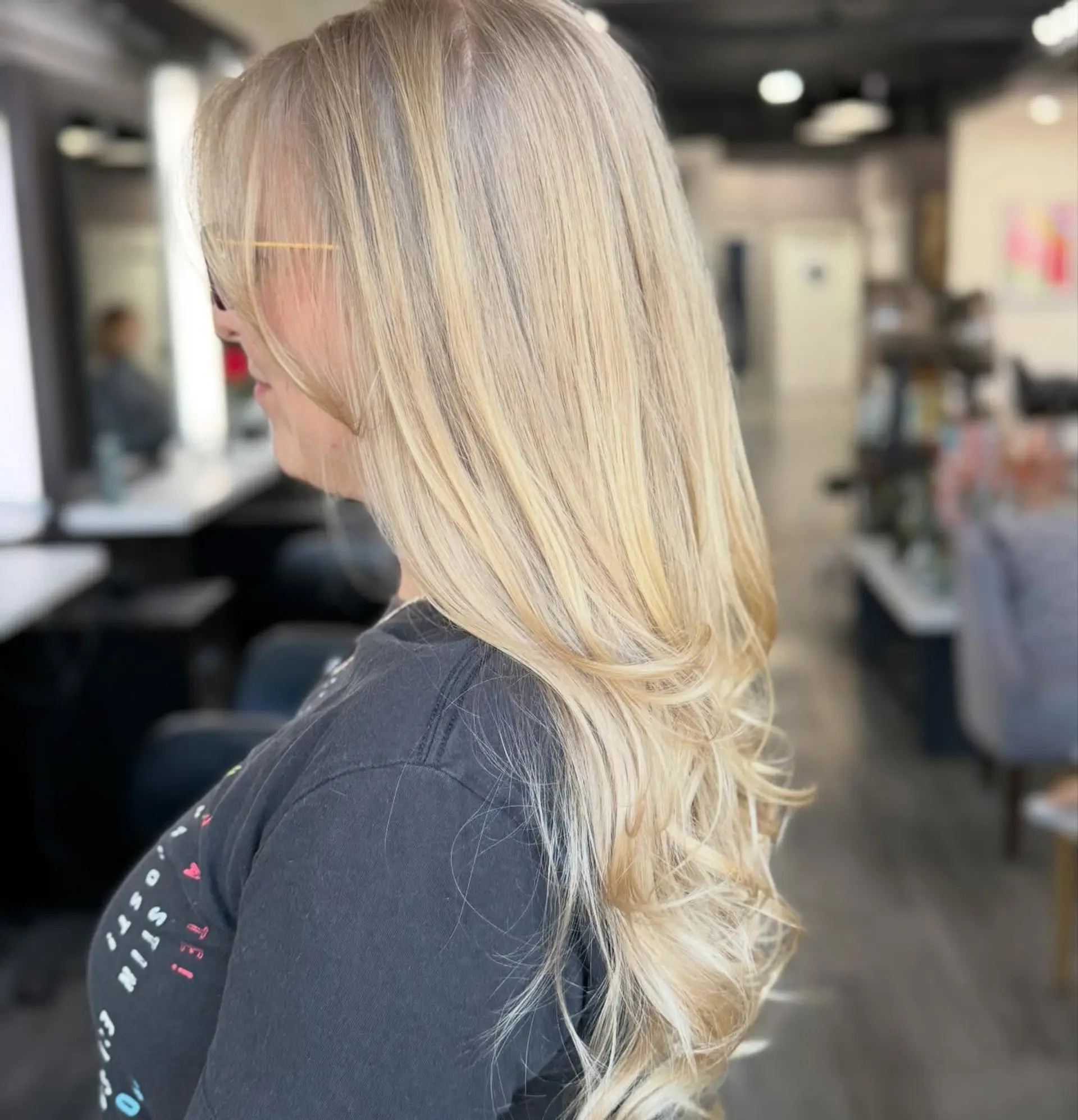 Long blonde hair styled with face-framing layers and soft, curled under ends. 1