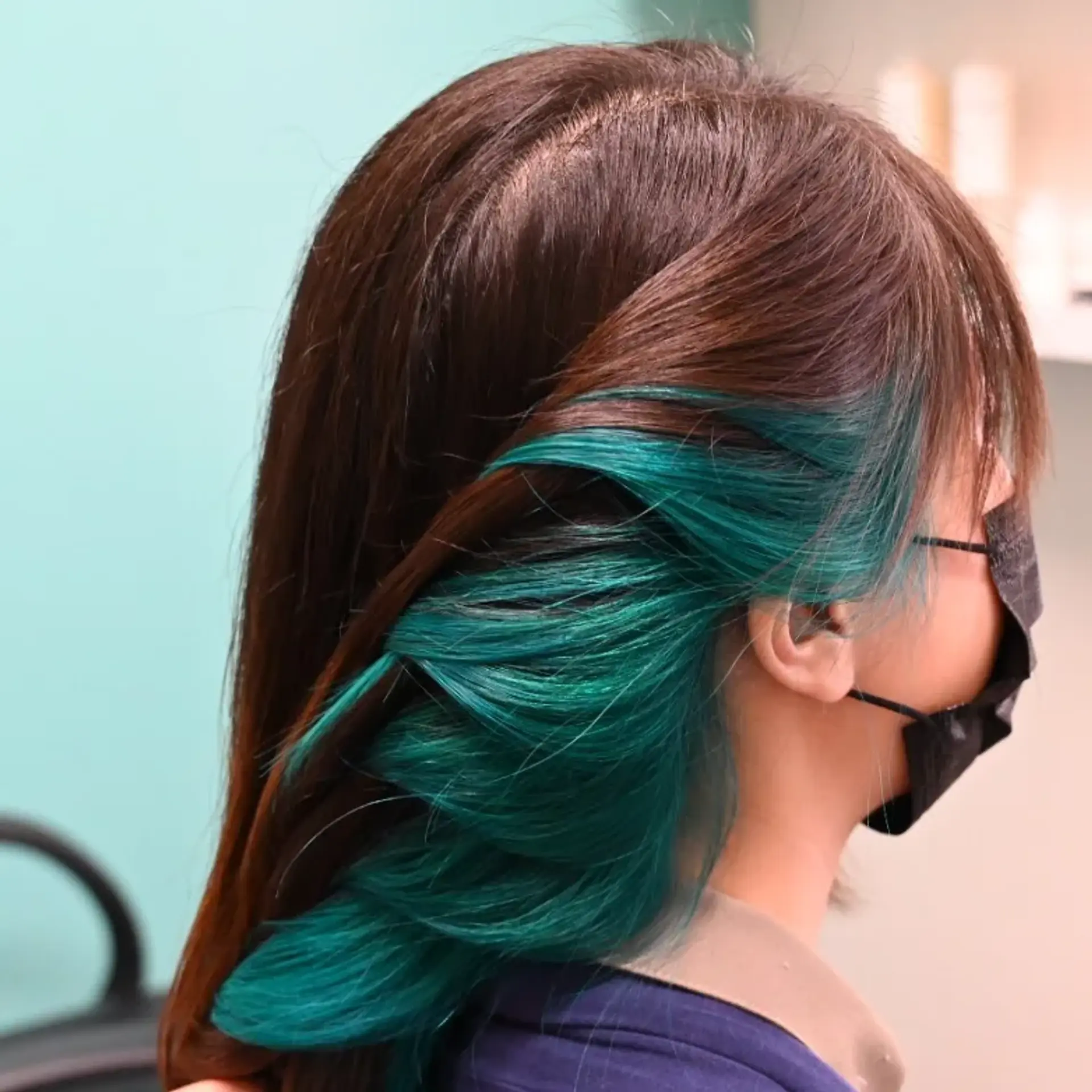 Dark brown straight hair featuring vibrant teal peekaboo inner coloring around the ears. 1