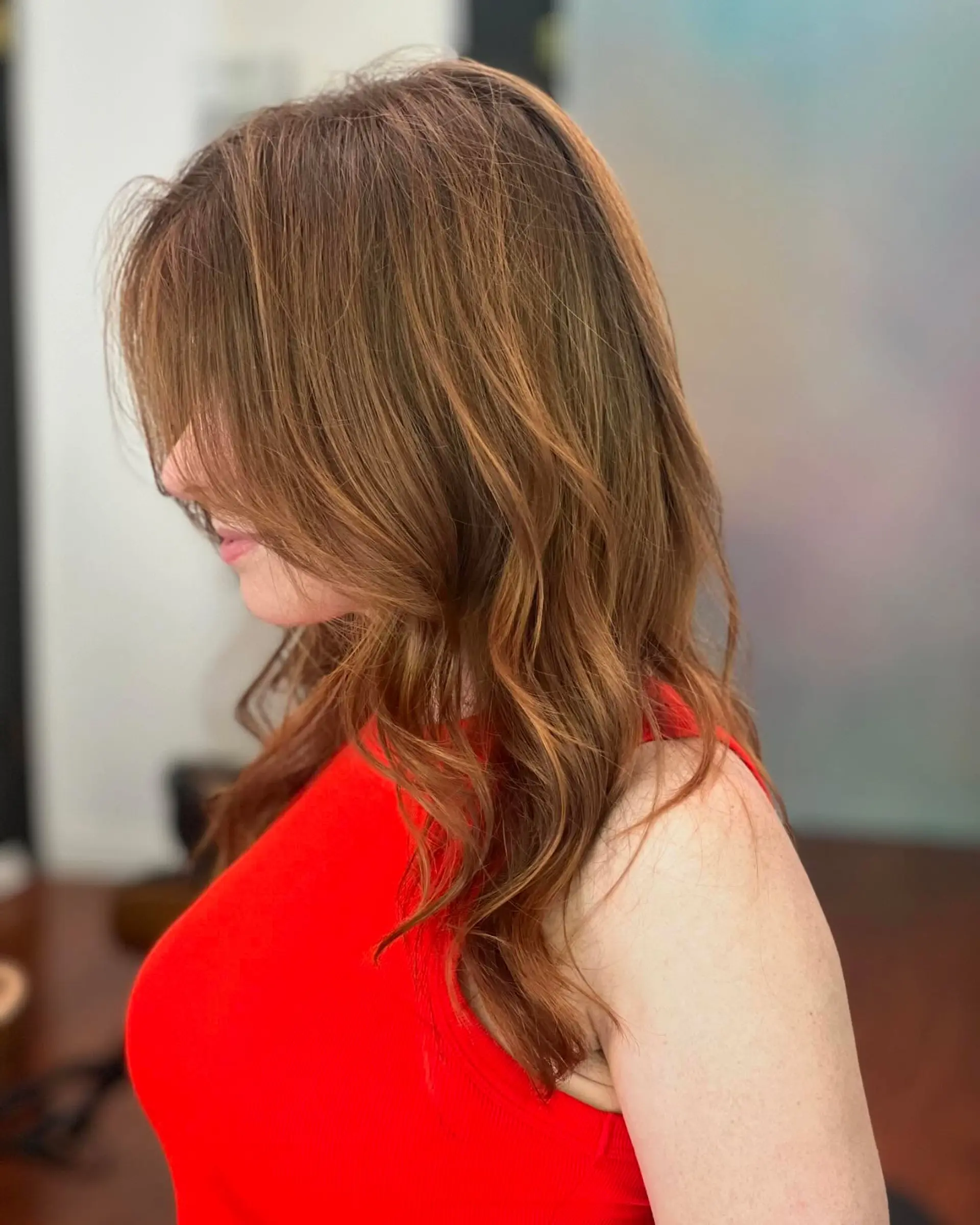 A long layered cut styled in loose, soft waves with face-framing pieces and subtle natural highlights. 1