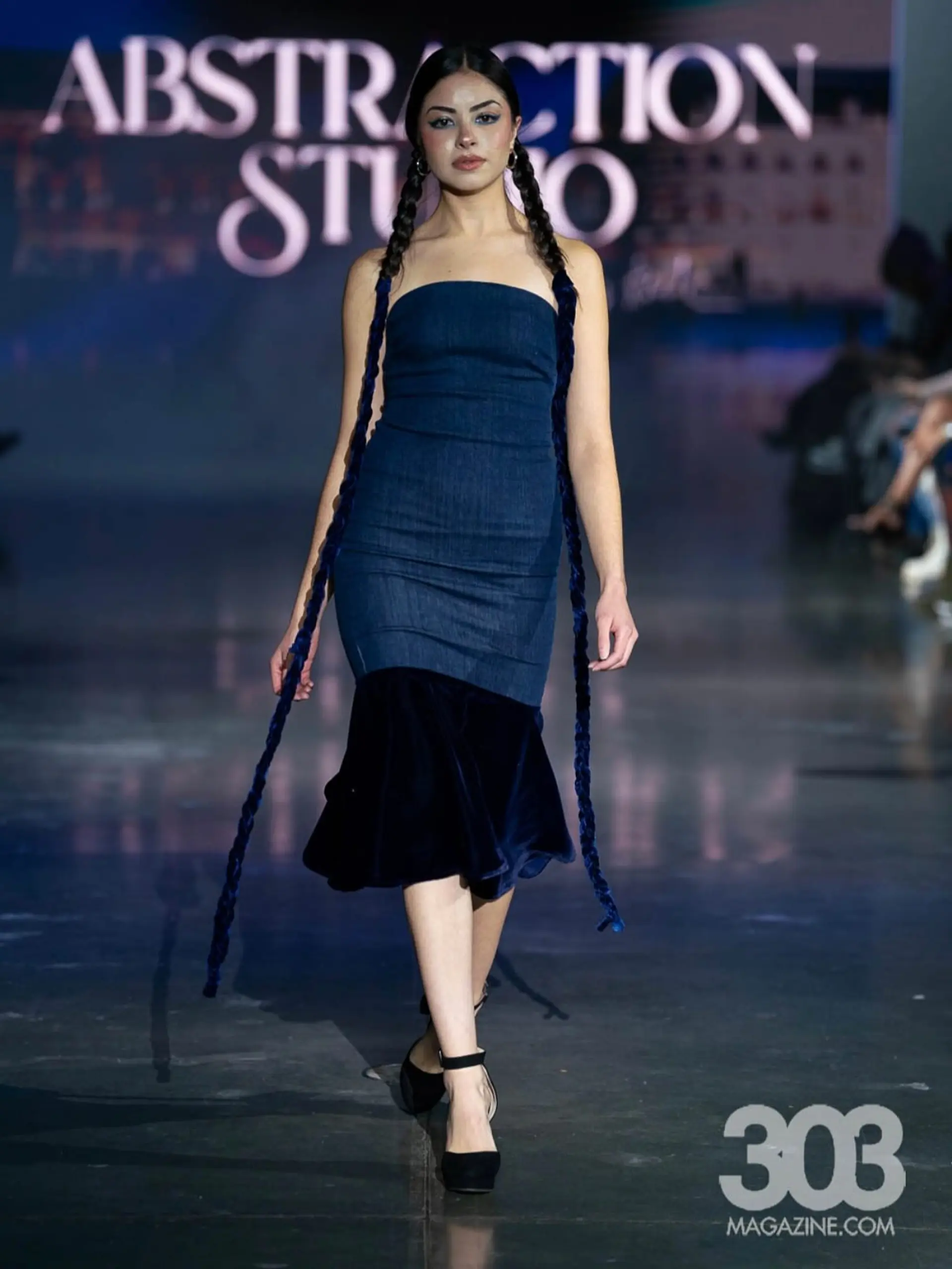 Sleek center-parted pigtail braids interwoven with long navy blue velvet ribbons extending past the knees. 1