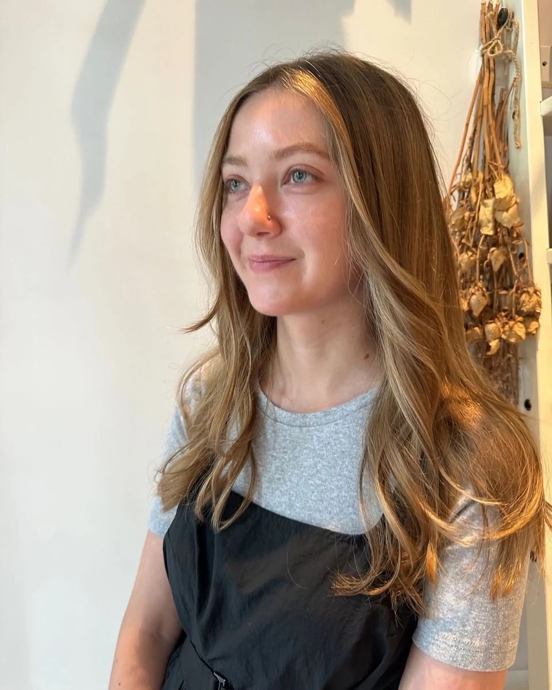 A long, wavy hairstyle with warm golden blonde face-framing highlights and subtle layering. 1