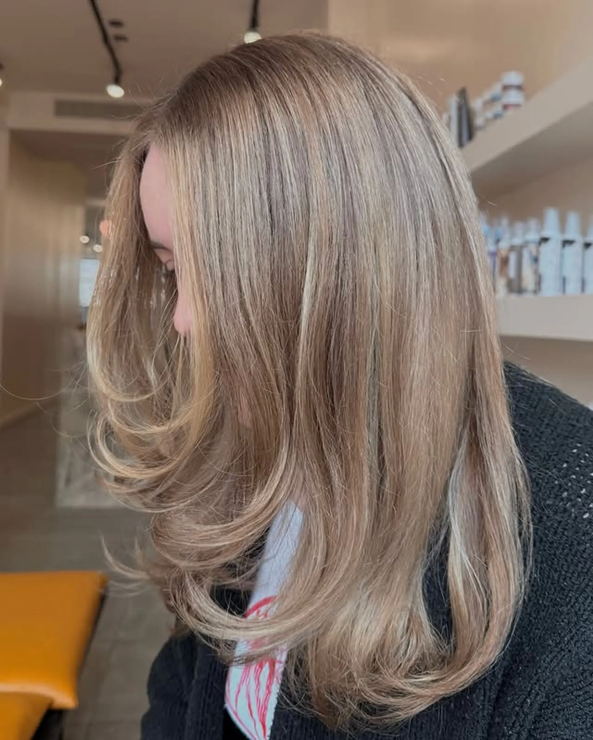 A medium-length layered haircut with face-framing layers and buttery blonde highlights. 1