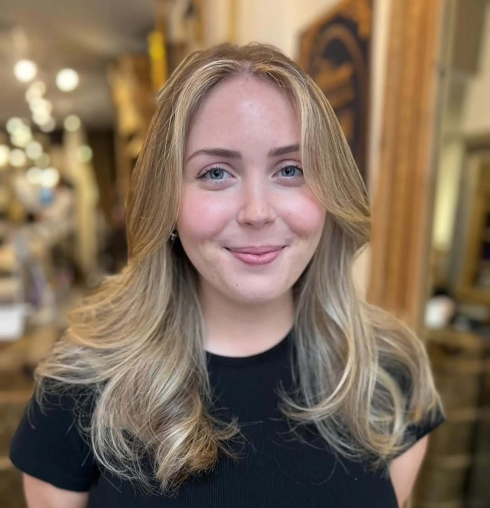 Long, wavy blonde hair with layers and a natural flow, featuring soft waves and warm honey tones. 3