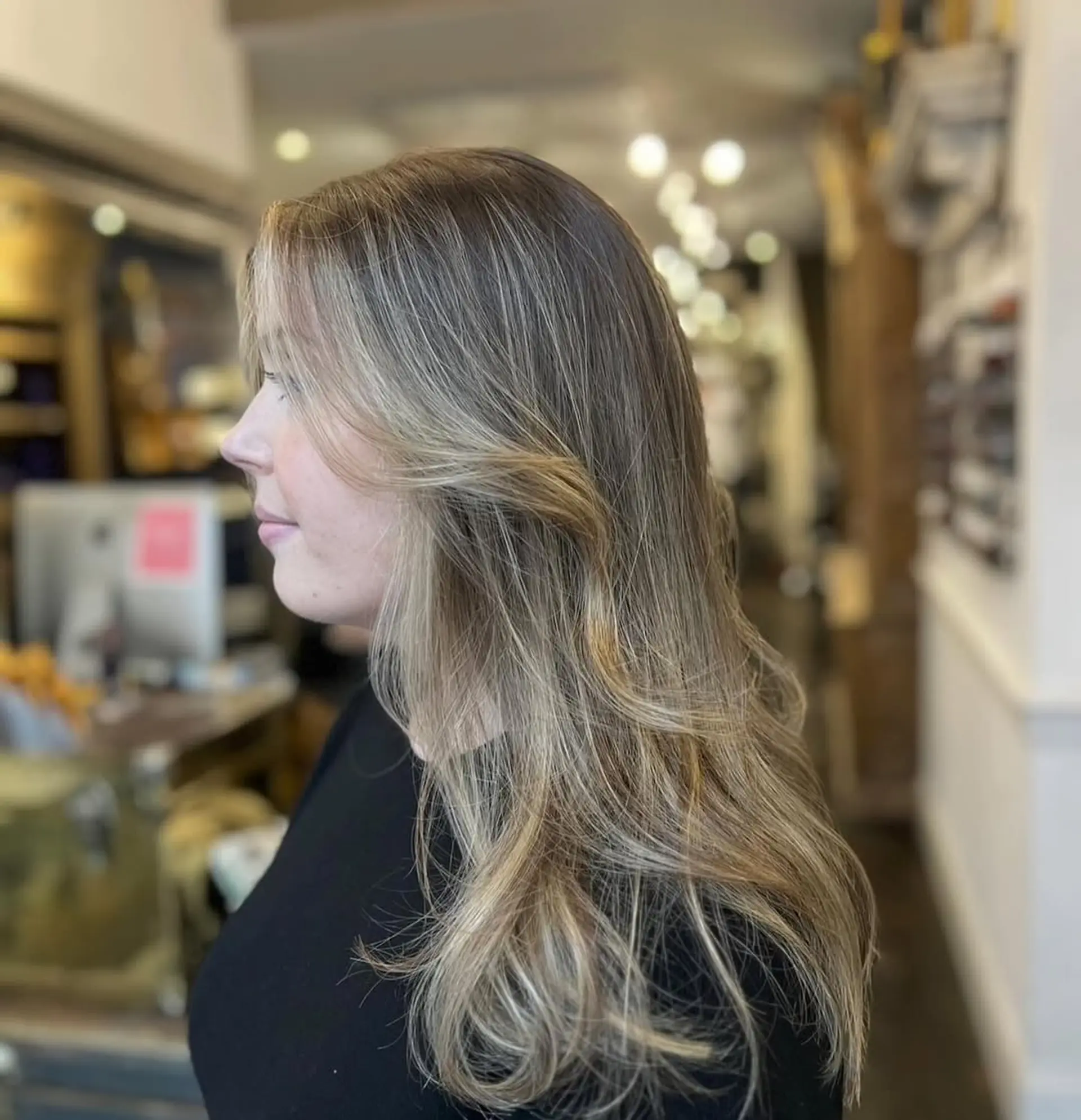 Long, wavy blonde hair with layers and a natural flow, featuring soft waves and warm honey tones. 2