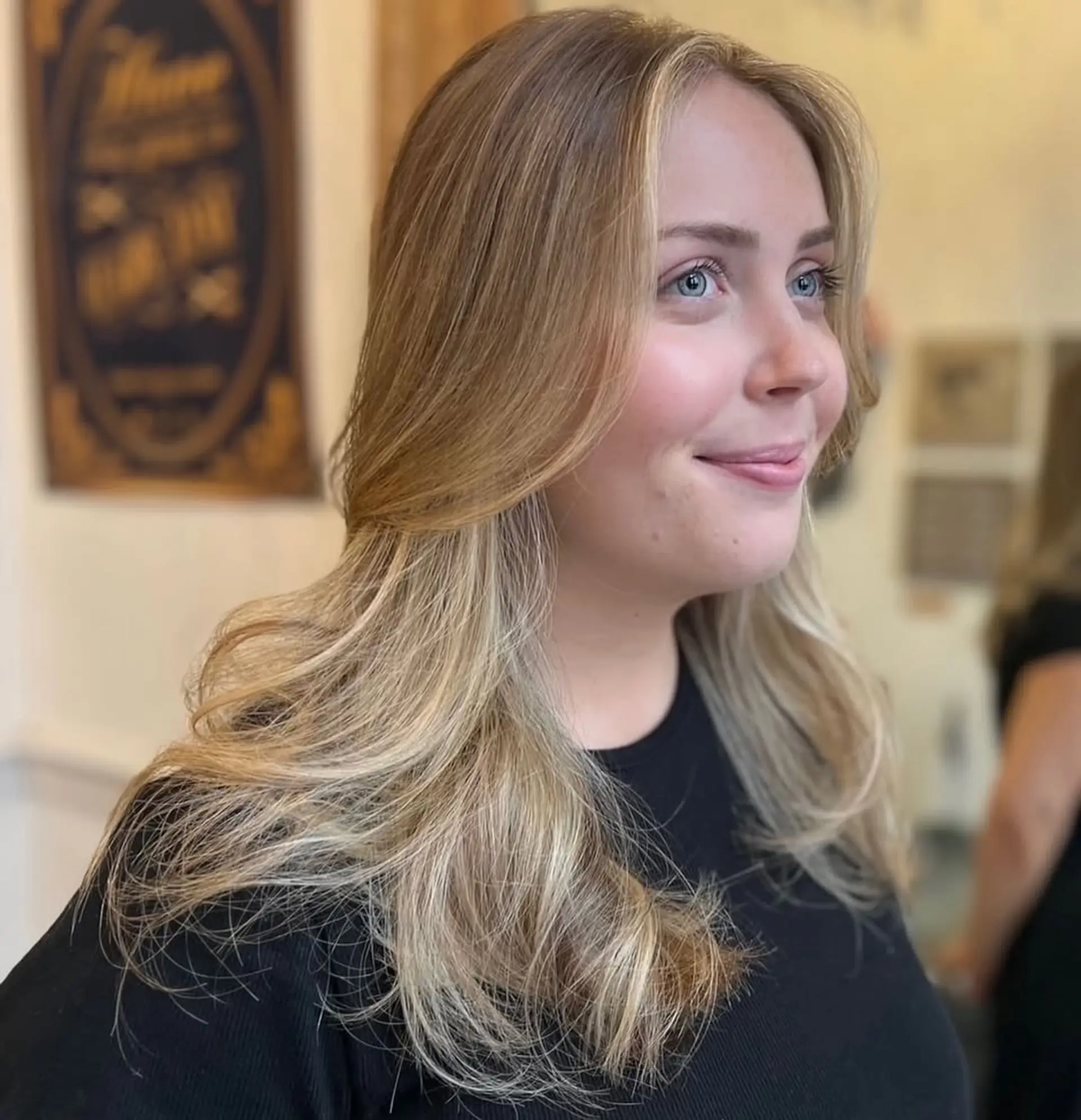 Long, wavy blonde hair with layers and a natural flow, featuring soft waves and warm honey tones. 5