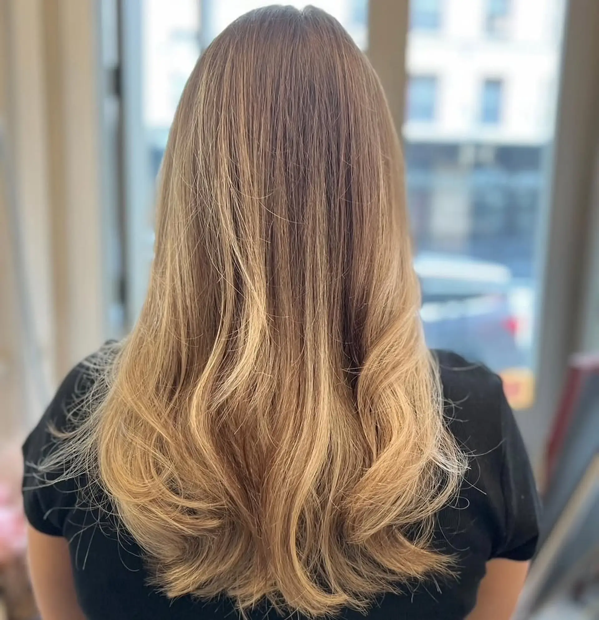 Long, wavy blonde hair with layers and a natural flow, featuring soft waves and warm honey tones. 1