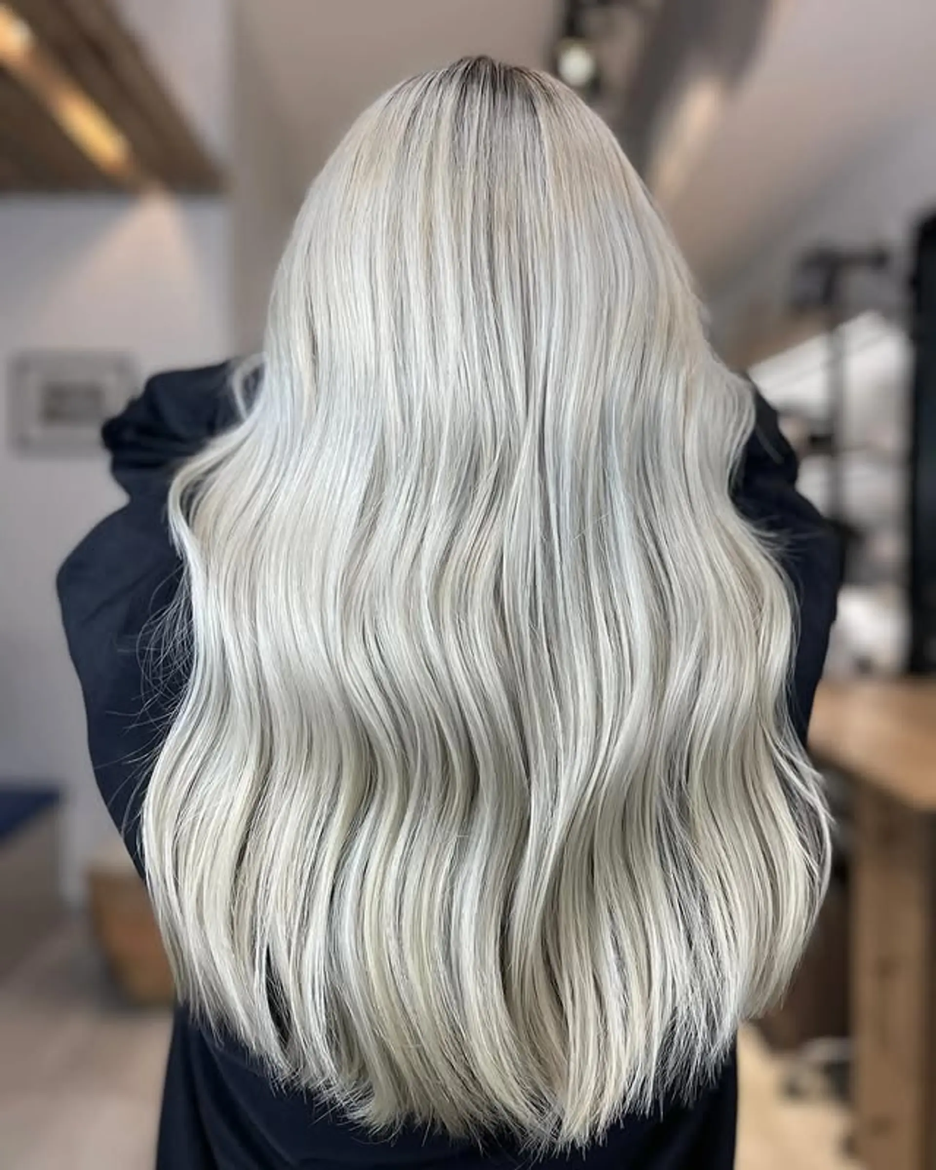 Long, soft waves with icy platinum blonde color and darker roots. 1