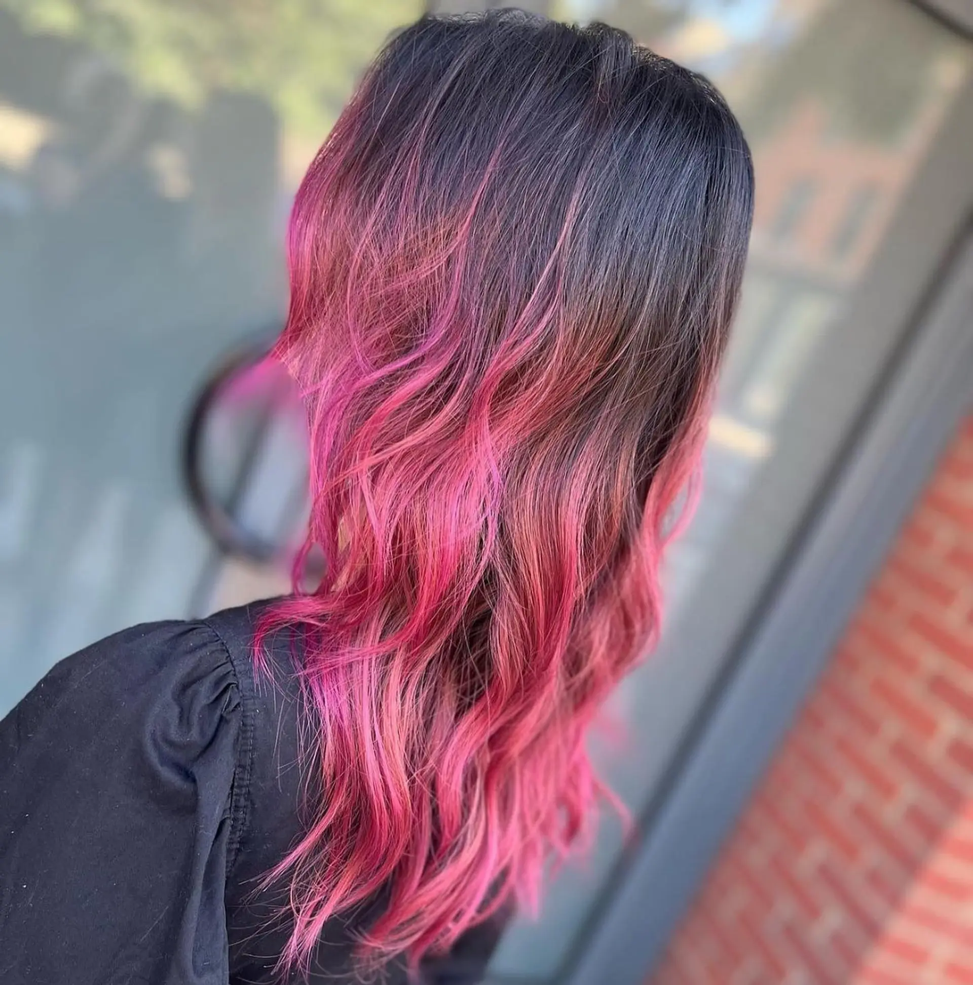 Long, wavy hair with a black to pink ombre effect, medium layers, and a striking two-tone color combination. 1