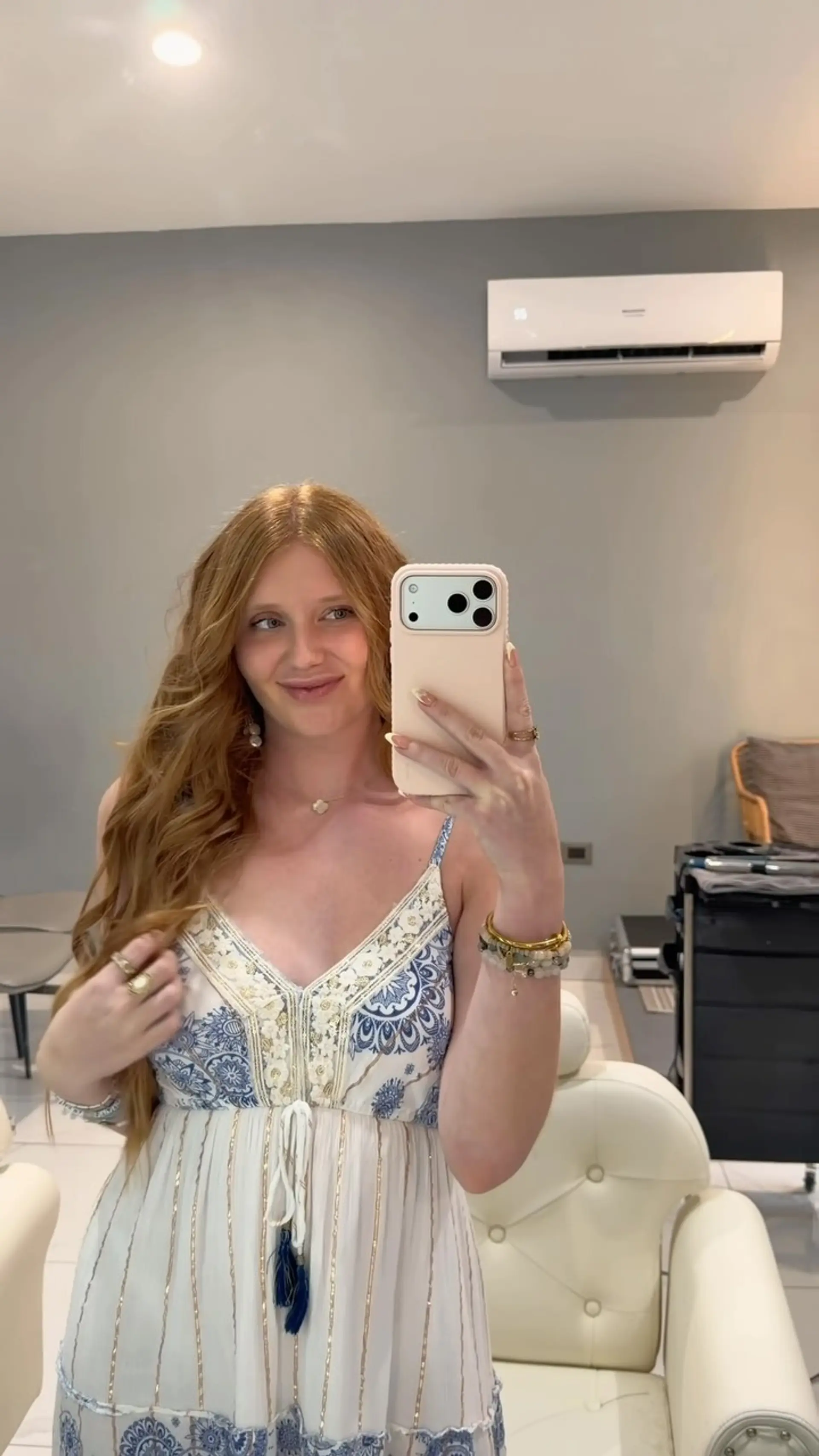 Long, voluminous strawberry blonde hair styled with soft waves and a middle part. 1