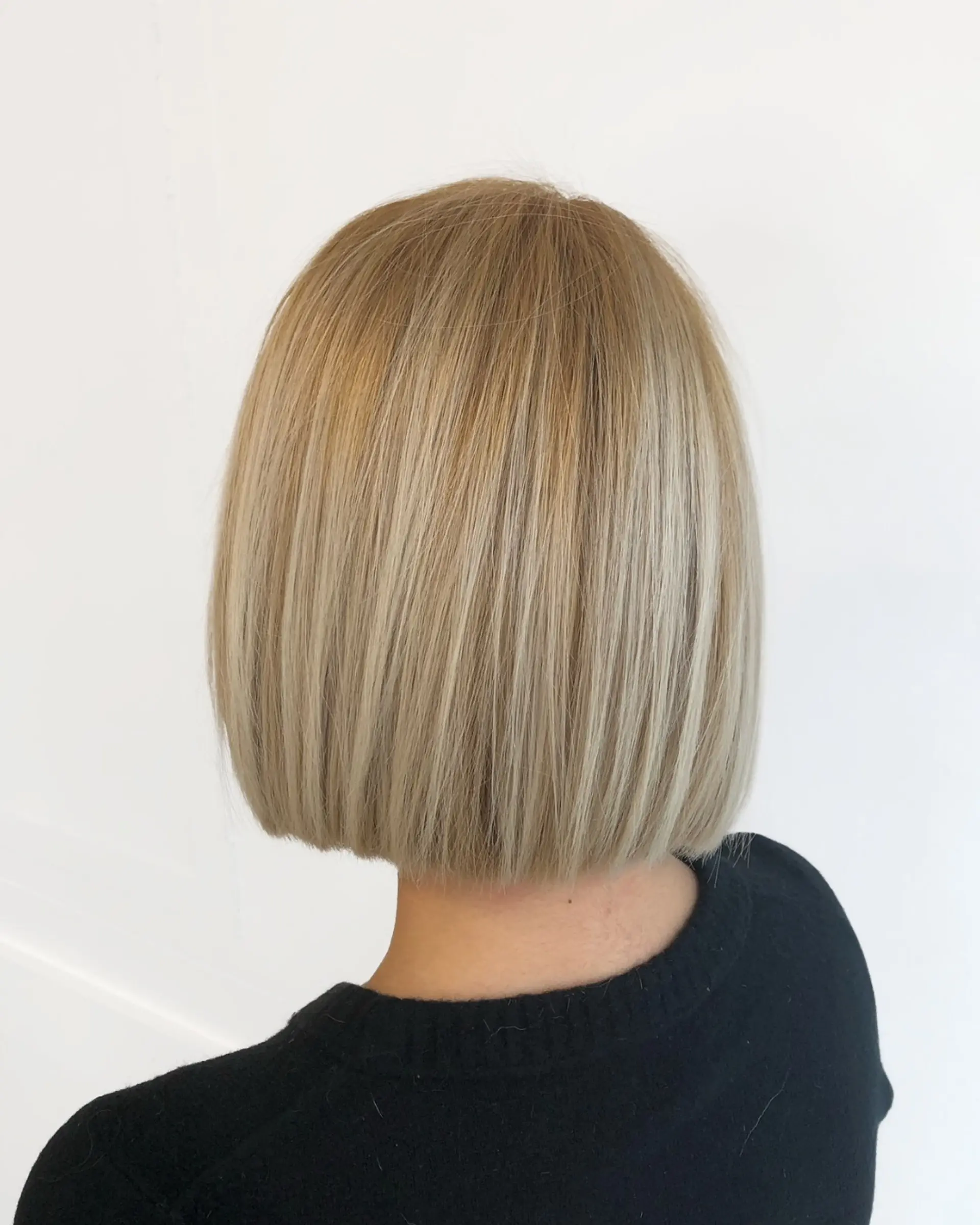 A sleek, straight blonde blunt bob cut with a smooth, glossy finish. 1