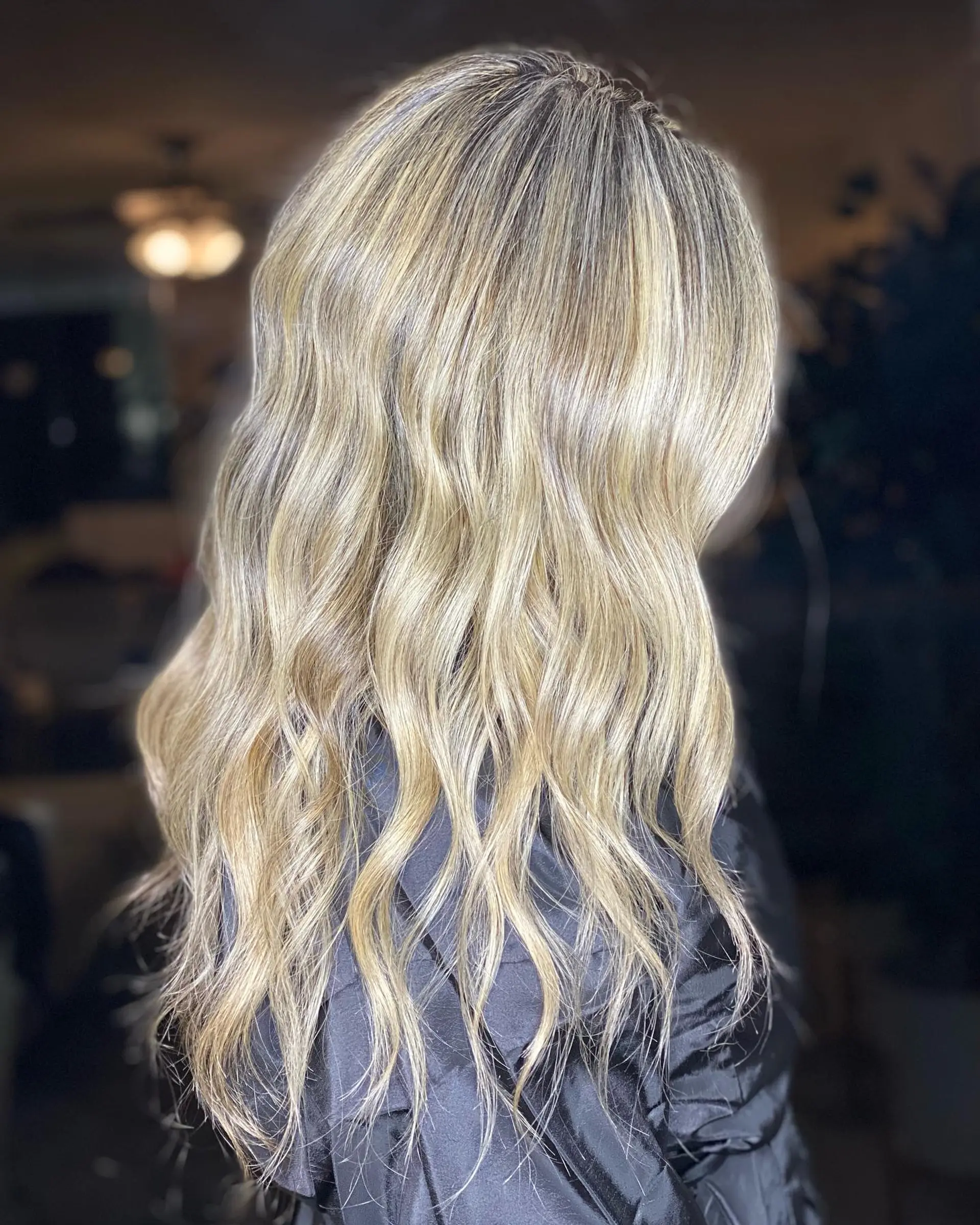 Long dimensional blonde hair styled in soft, undone waves with finely woven full-head highlights. 1