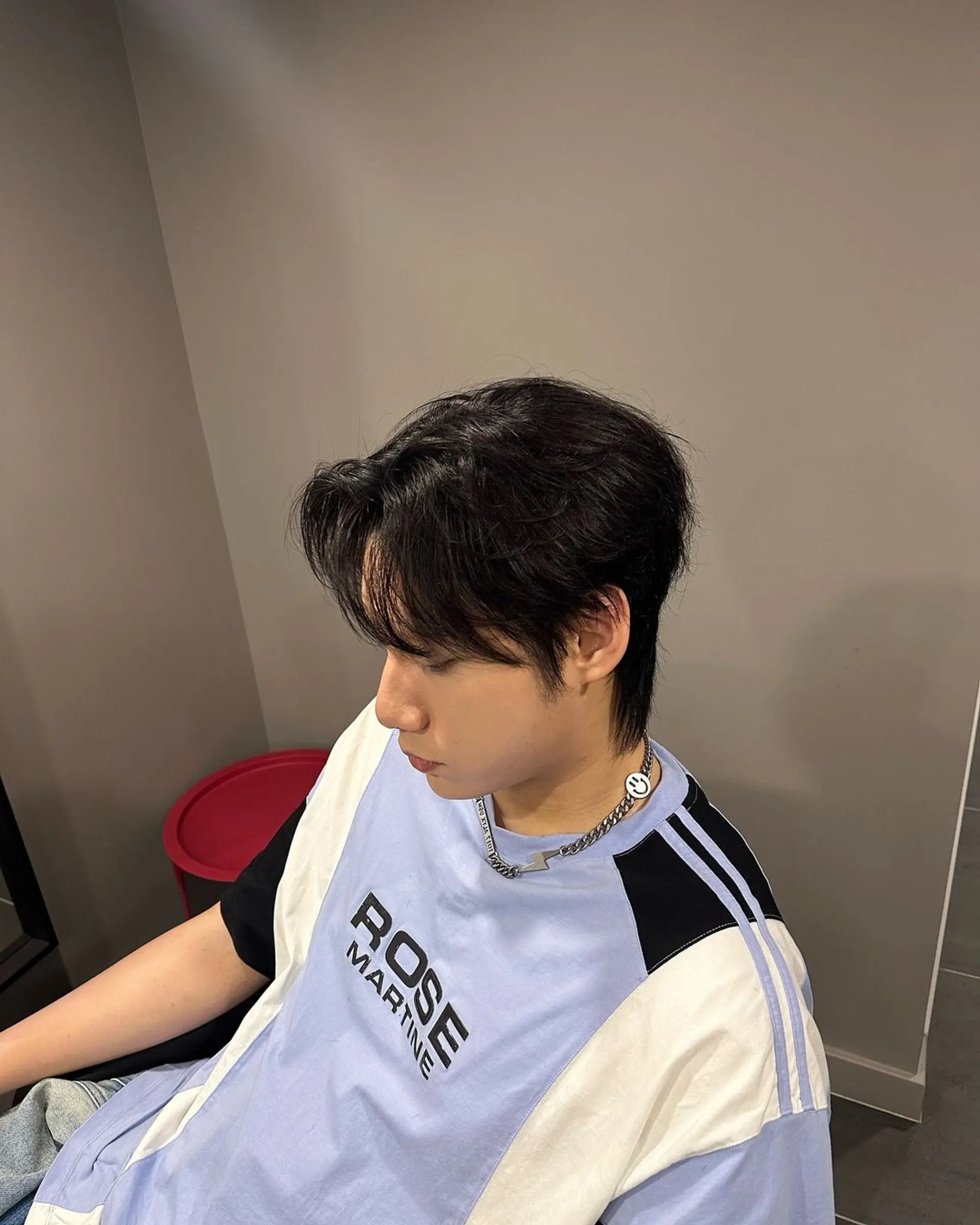 A trendy look with medium-length black hair that is naturally wavy. Features a textured fringe flowing across the forehead, with layers adding volume and depth, and waves giving a soft, tousled effect. 1