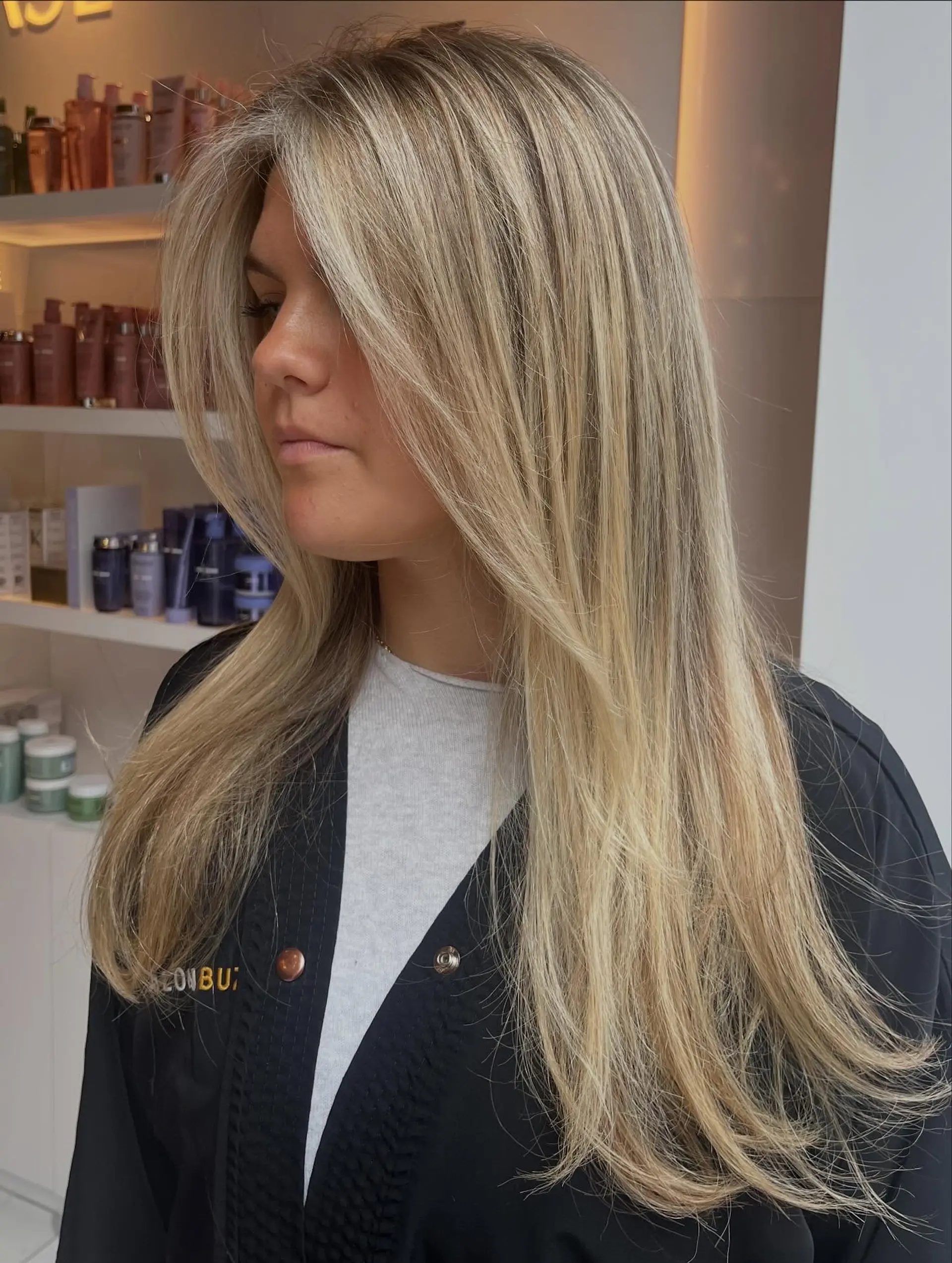 Long, multi-dimensional honey blonde hair styled with soft, face-framing curtain layers and a sleek blowout. 1