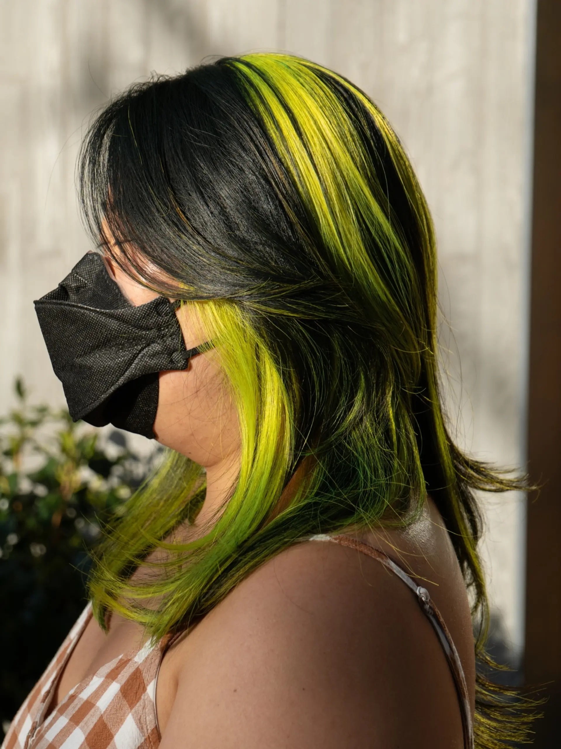 A medium-length layered cut with dark hair featuring vibrant neon slime green color-blocked panels framing the face and crown. 1
