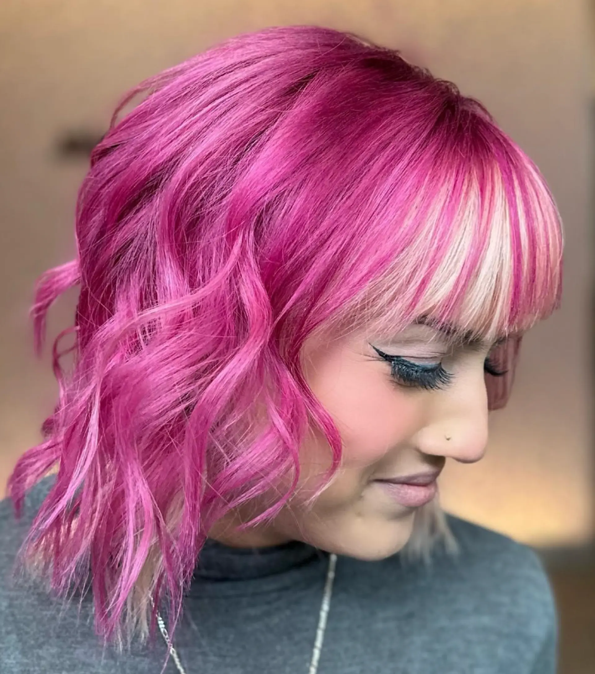 Medium-length wavy hair in magenta pink with blunt blonde bangs, featuring bold contrast and playful, edgy waves.

Color by @simabeautynyc
Cut by @juliamannino_hair
 1