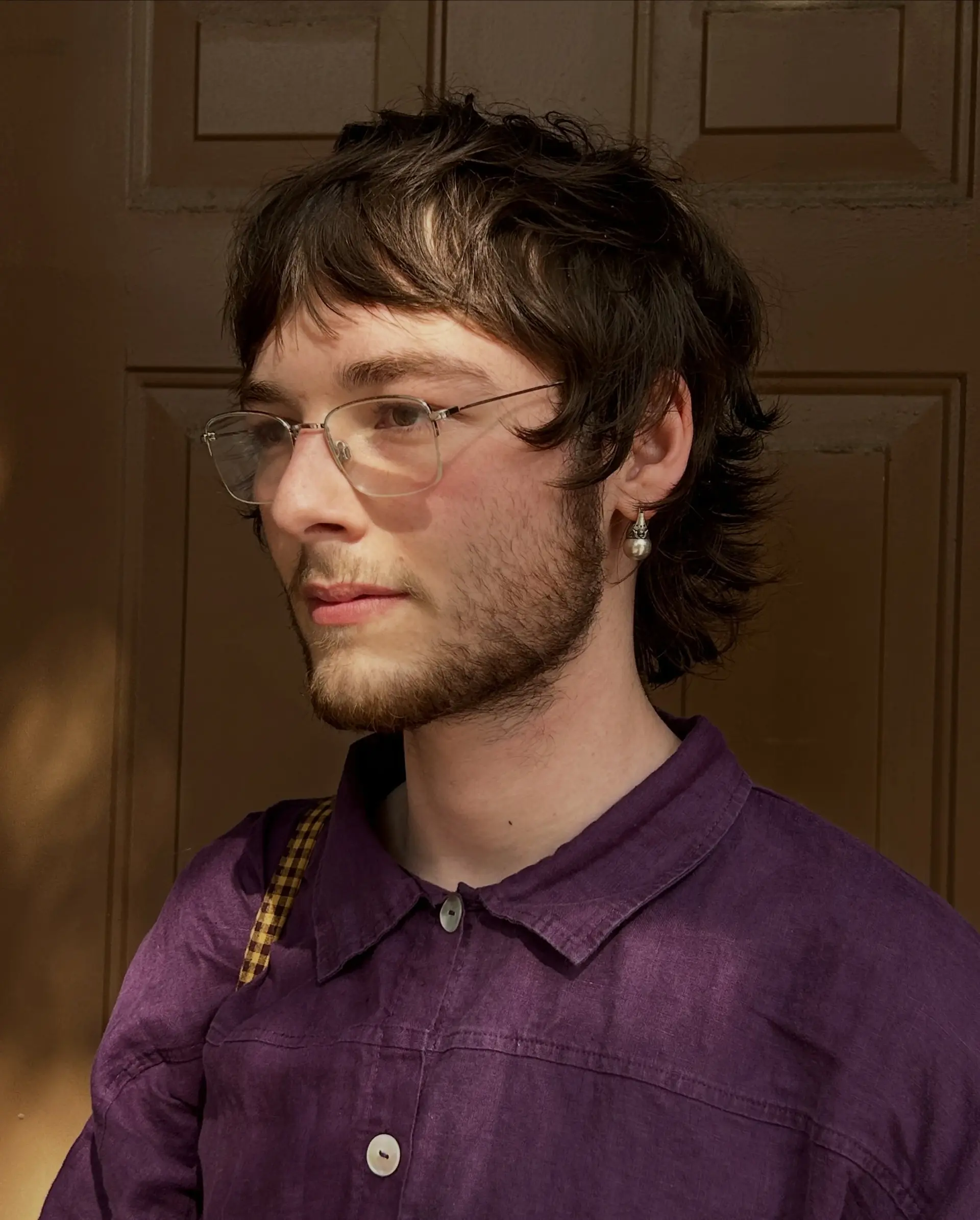 A textured mod mullet cut with piecey micro-bangs and soft feathered layers flicking out at the nape. 1