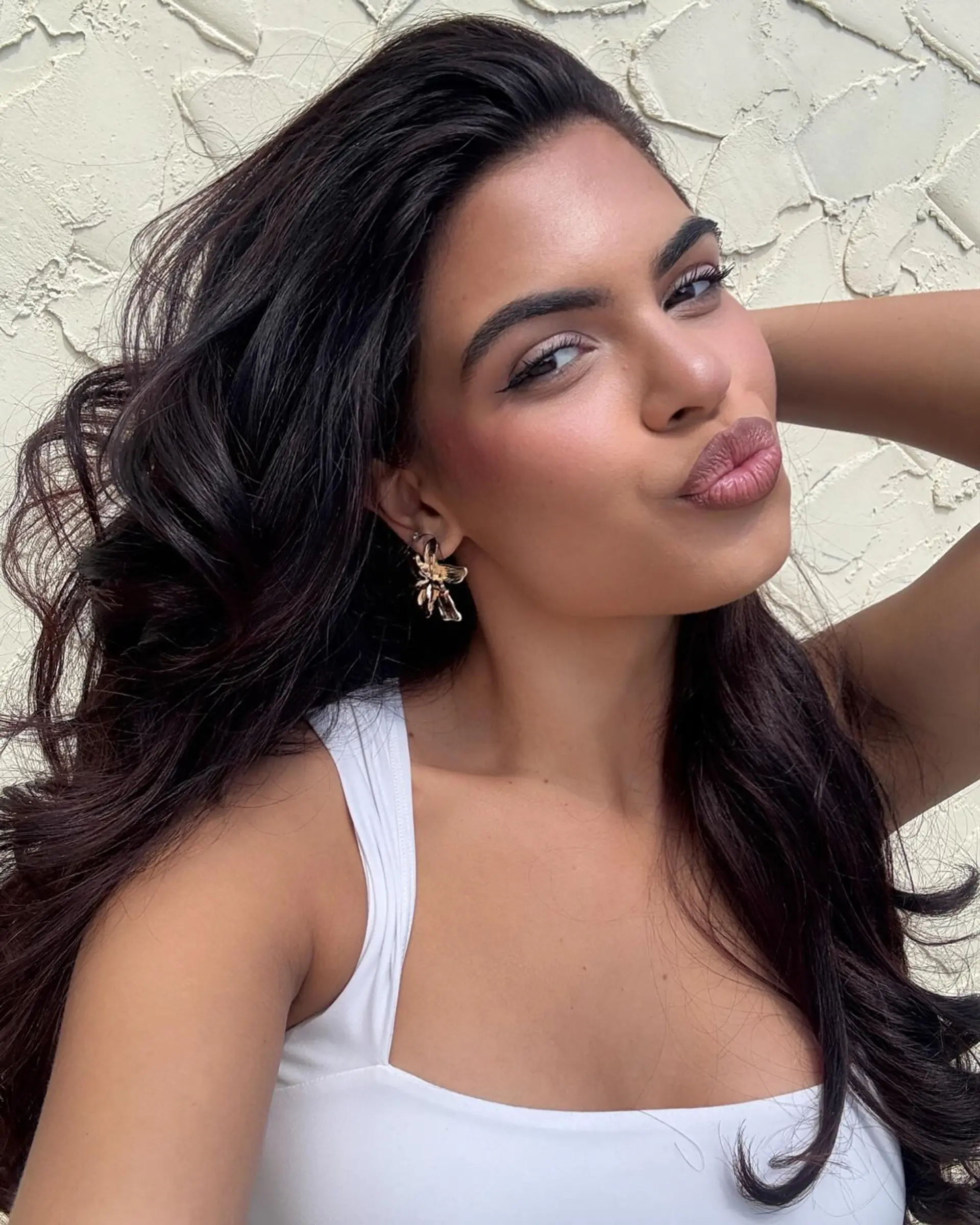 A romantic hairstyle featuring long, voluminous waves with subtle layering for added dimension and movement. 1