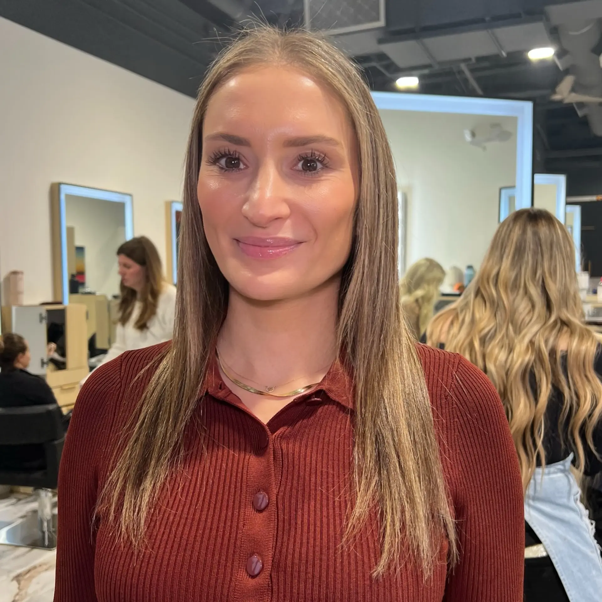 Straight, long hair parted in the middle featuring blended blonde highlights and enhanced density through the ends. 1