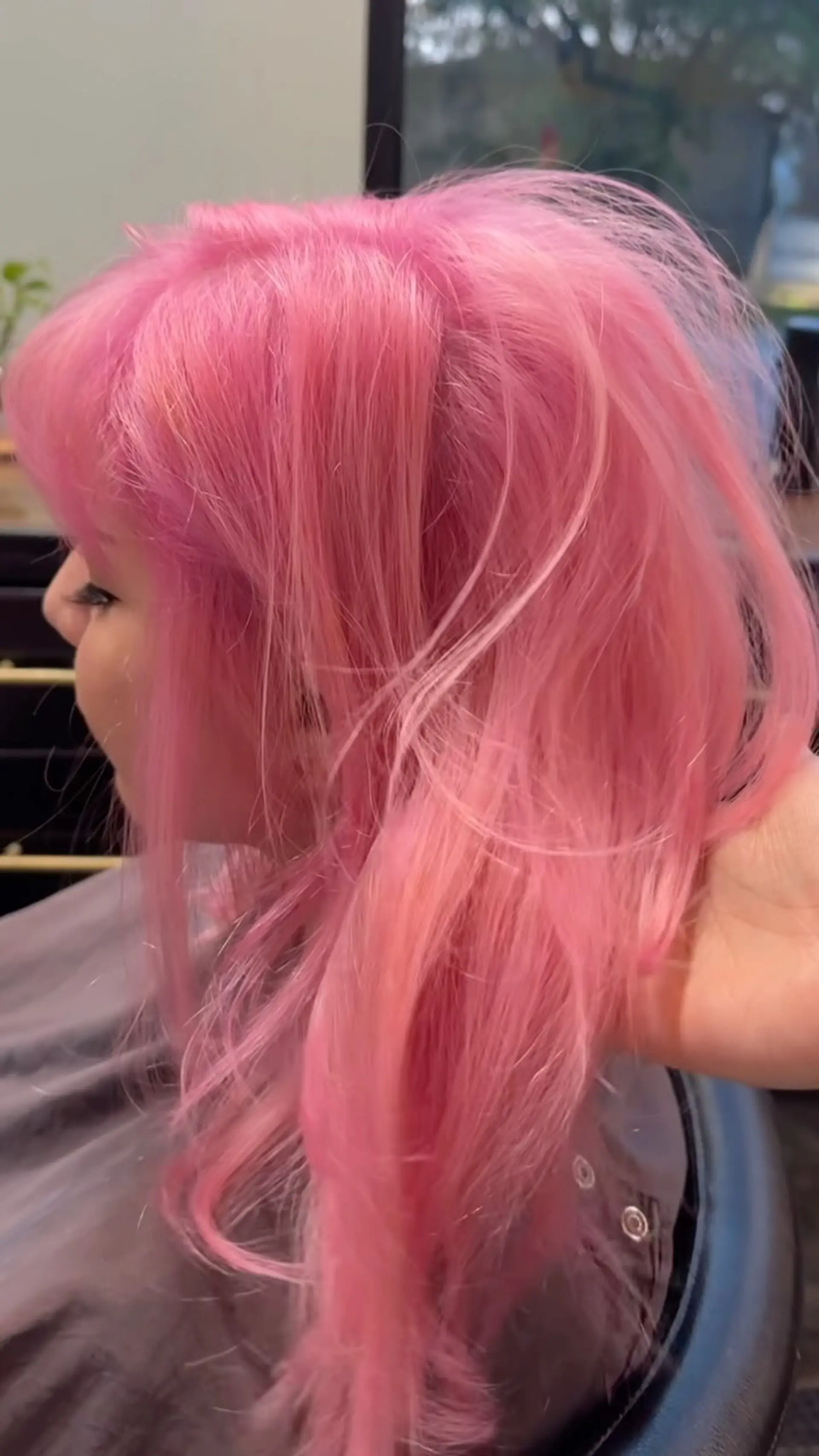 Medium-length textured hair with full bangs colored in an all-over pale bubblegum pink tone. 1