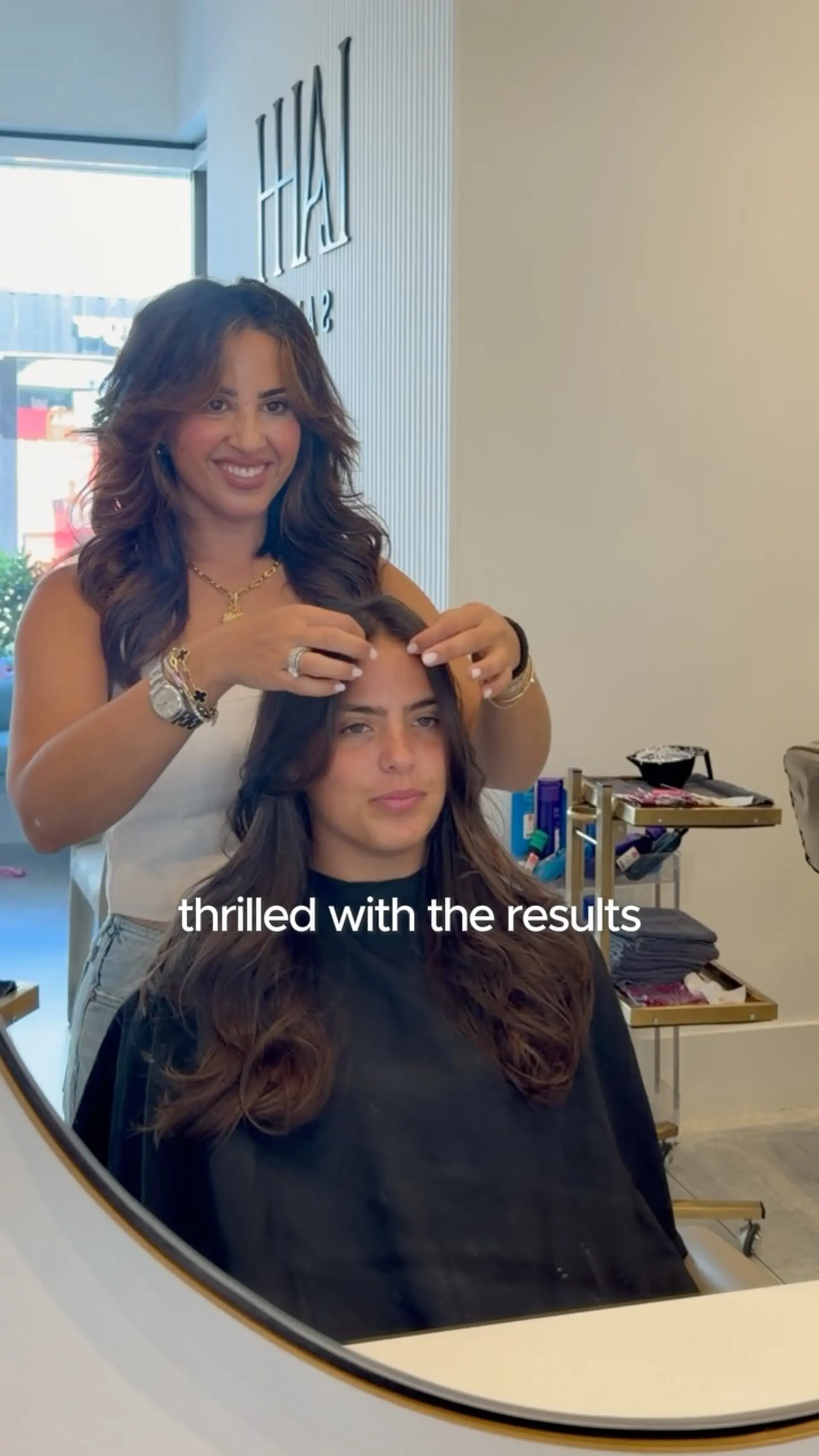 Long layered butterfly haircut styled with bouncy, voluminous waves and soft face-framing layers. 1