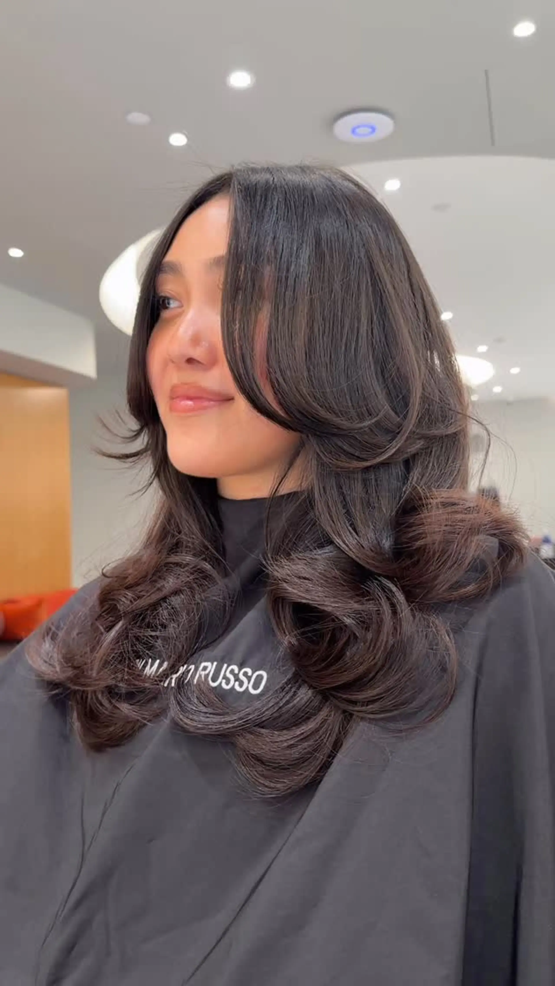 A long, voluminous butterfly haircut featuring cascading face-framing layers and polished curved ends. 1