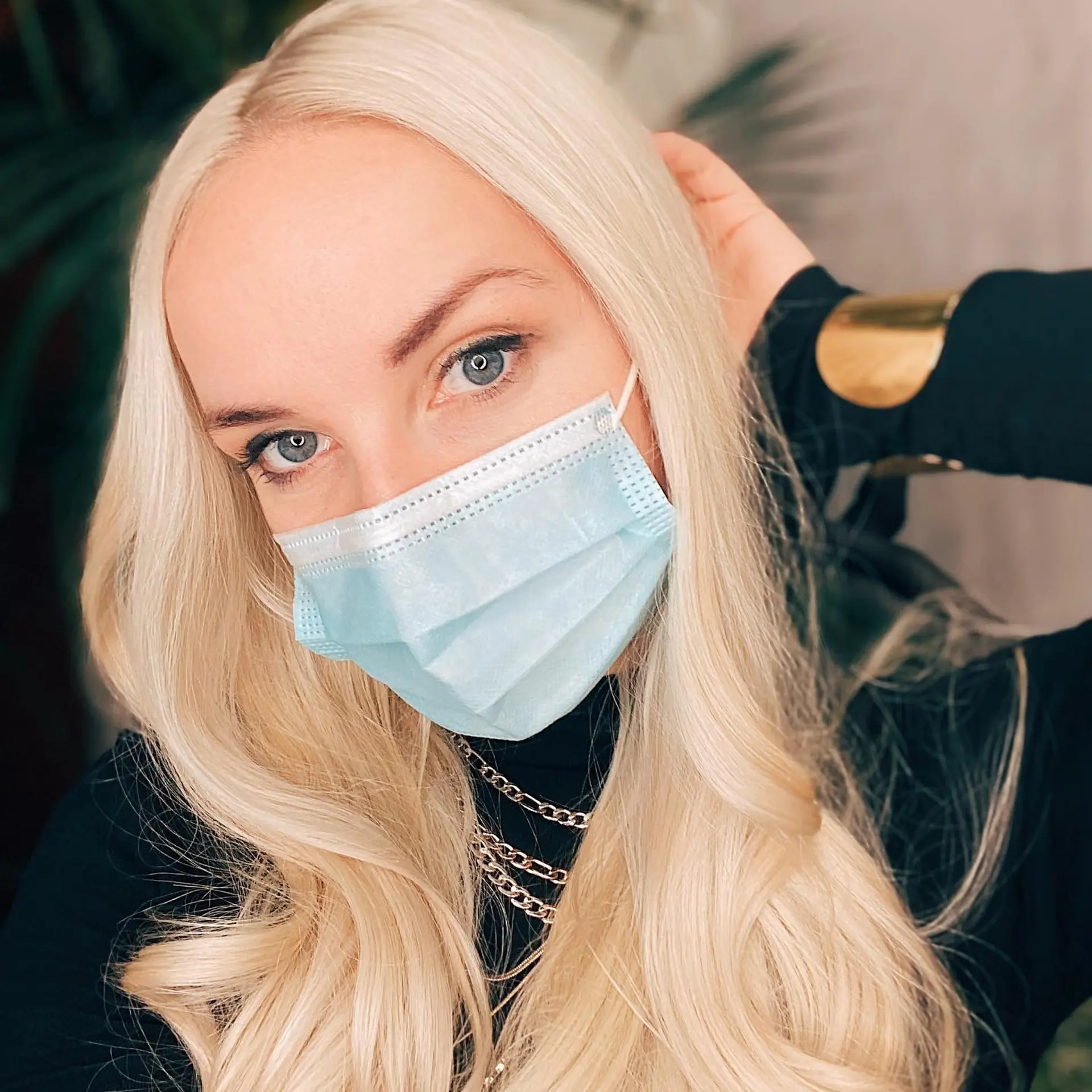 Long, luminous platinum blonde hair styled with a center part and soft, polished waves curling toward the ends. 1