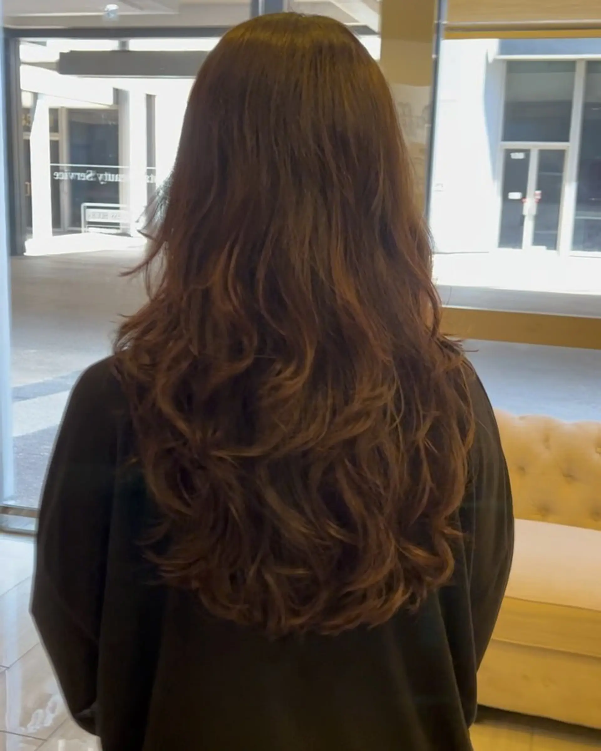 Long brown hair styled in soft, cascading layers with voluminous loose waves throughout the lengths and ends. 1