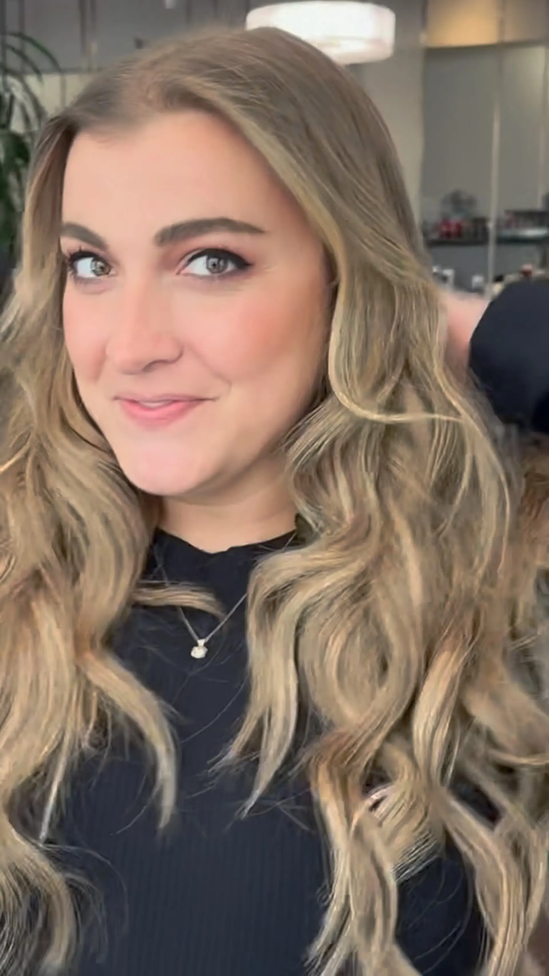 Long cascading waves featuring a dimensional blend of cool ash blonde and light brown tones. 1