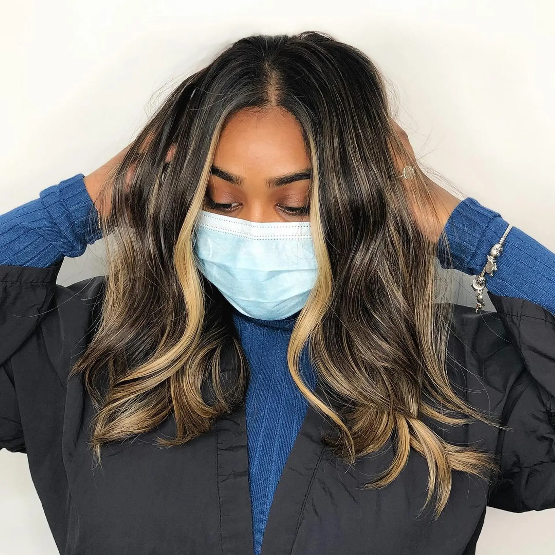 A medium-length, wavy hairstyle with dark brown hair and face-framing blonde highlights. The hair features soft, layered waves that add volume and texture, giving the look a dynamic and dimensional appeal.
Stylist - @xcellent_jason 1