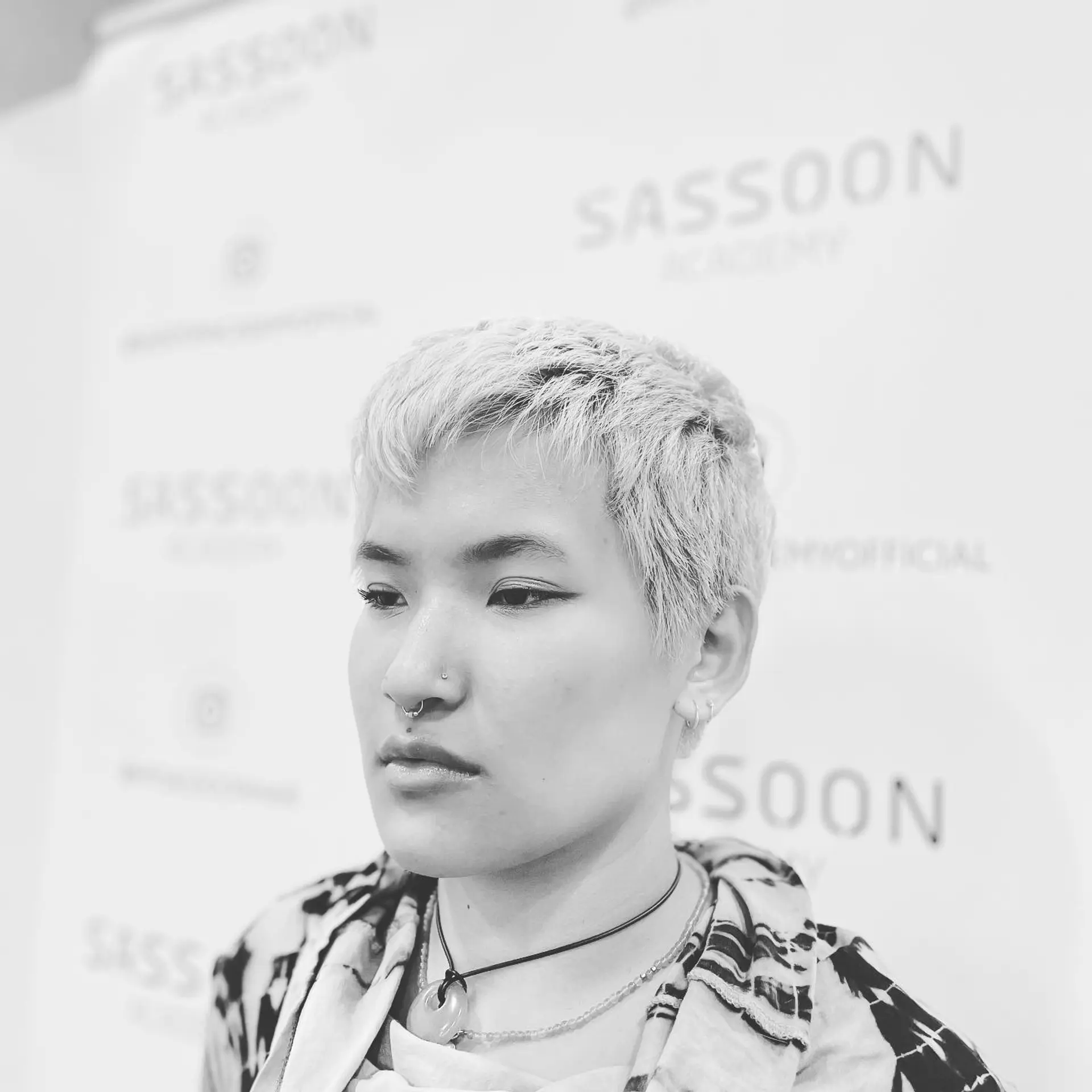 A short, textured pixie crop cut featuring a soft piecey micro-fringe and clean, tapered perimeter. 1