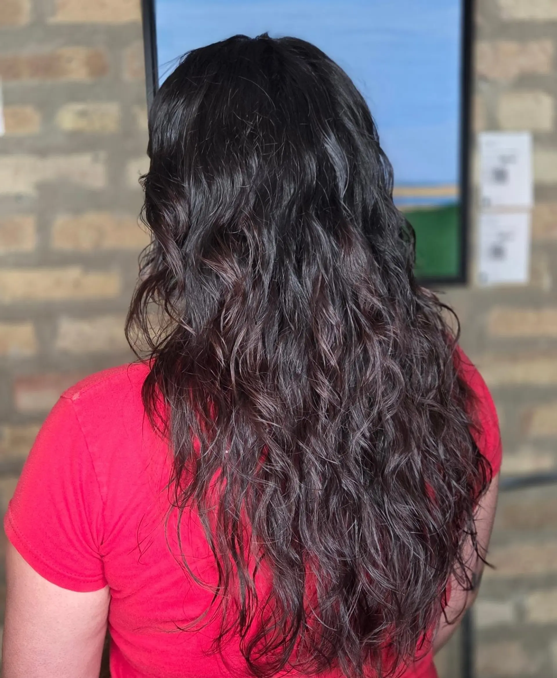 A long, textured shag haircut featuring cascading layers that accentuate natural wavy texture. 1