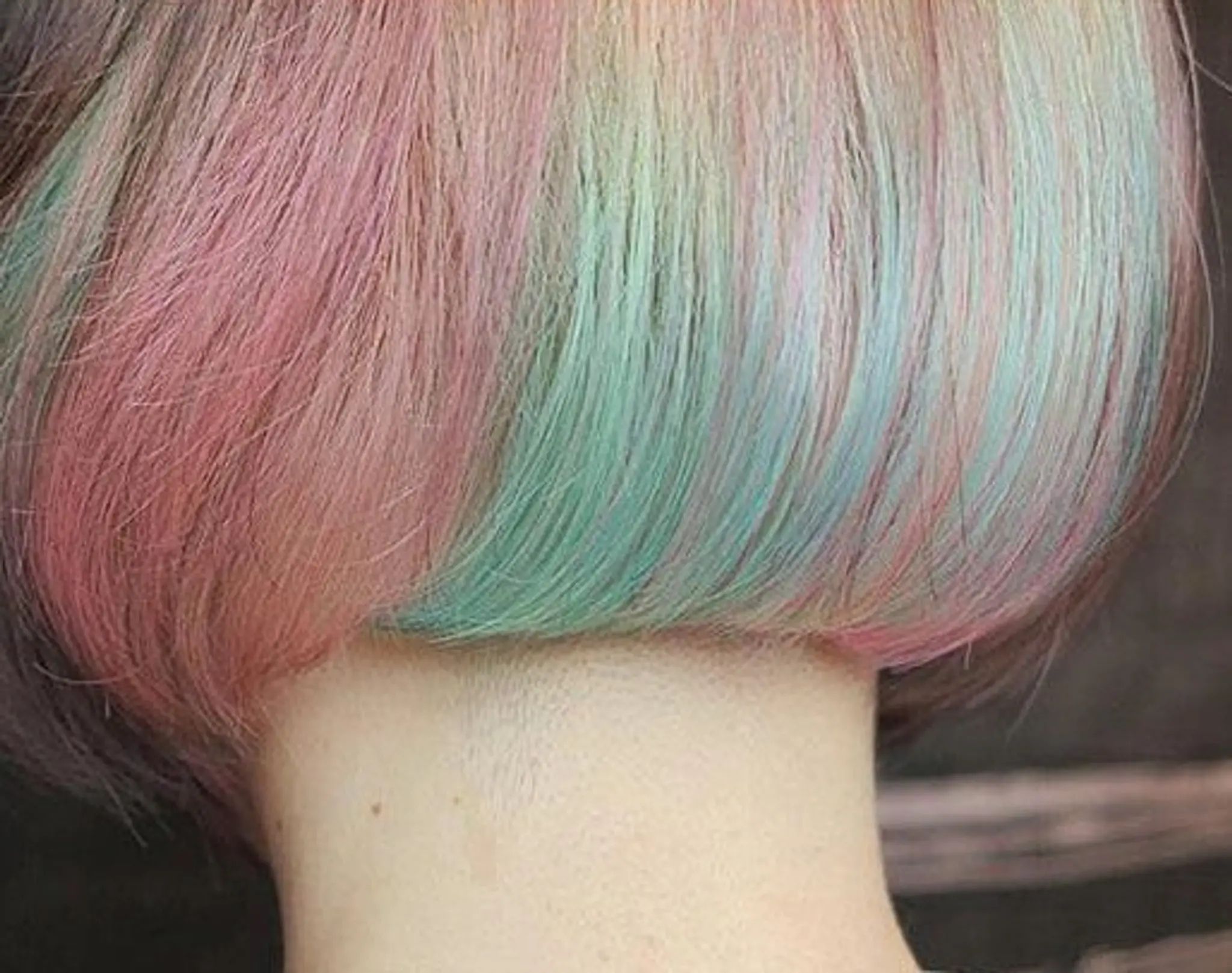 A vibrant straight bob with pastel pink, blue, green, and purple hues, featuring a smooth, layered cut.