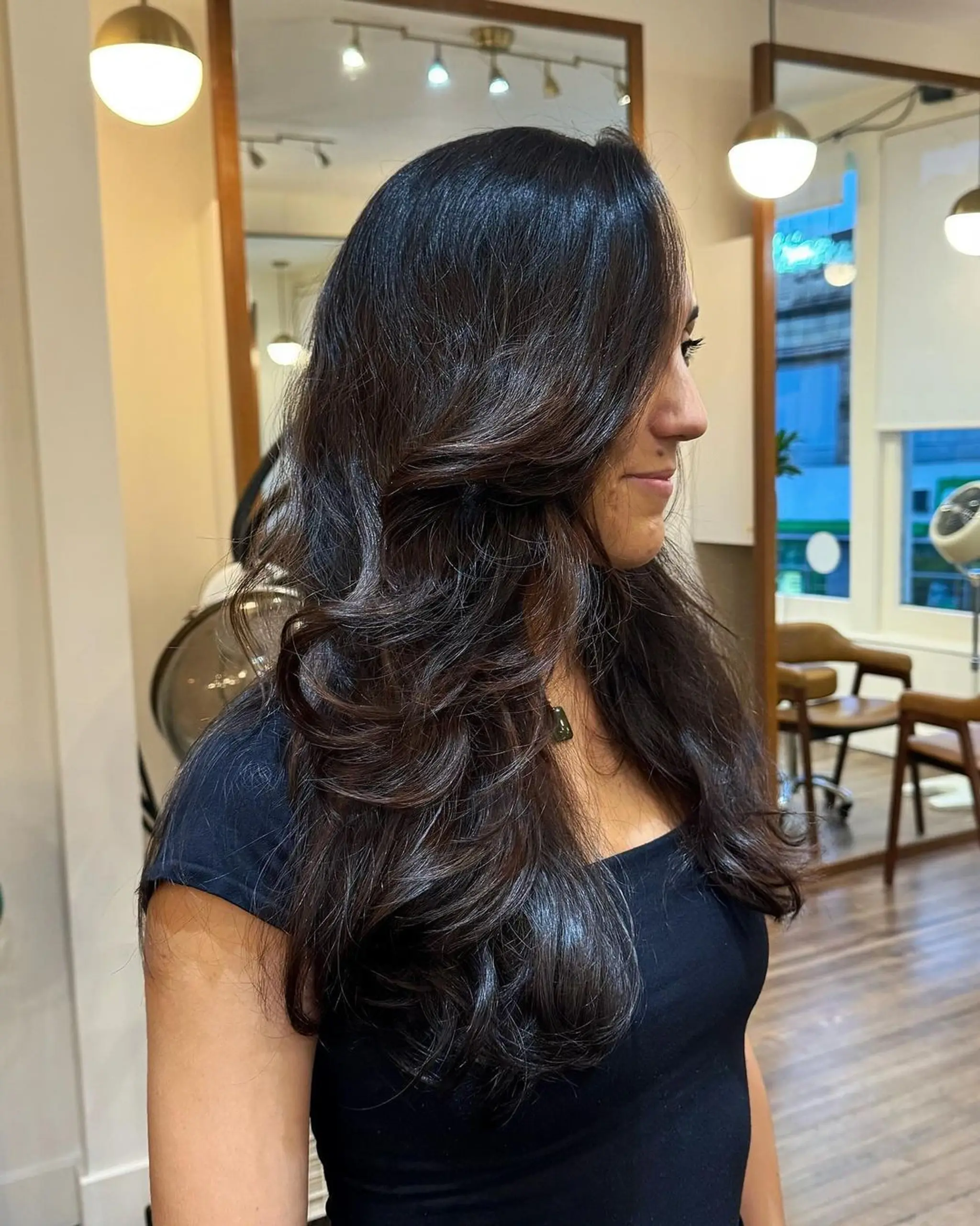Long dark brown wavy hair with a side part, featuring natural shine and elegant layers.